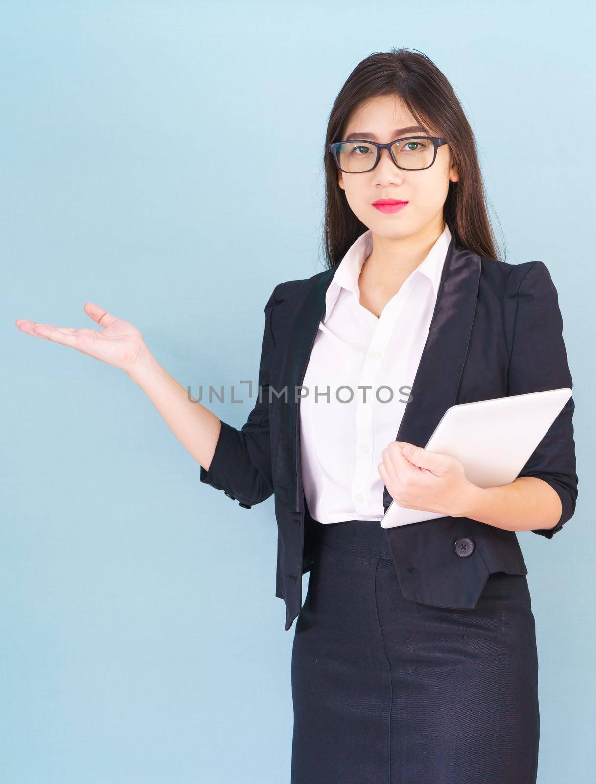 Young women standing in suit holding her digital tablet computor with finger pointing up