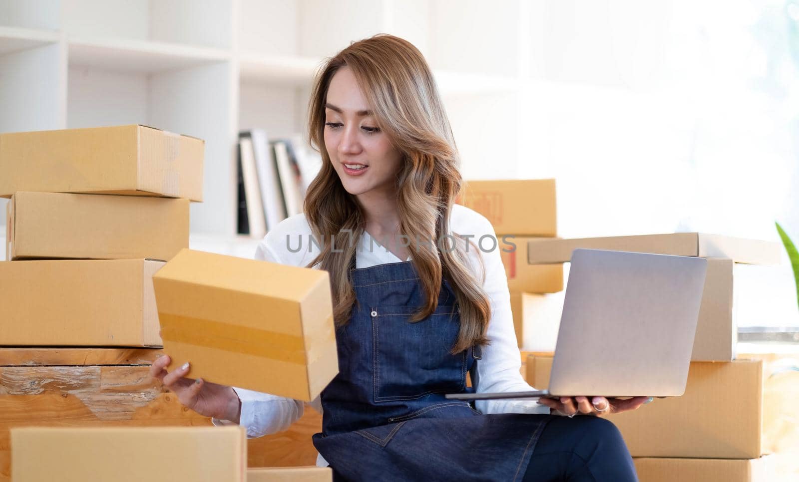 Starting a small business, SME owner, female entrepreneurs are using the rope to tie boxes to pack products Order online to prepare to pack a box of goods for sale to customers, sme business idea.