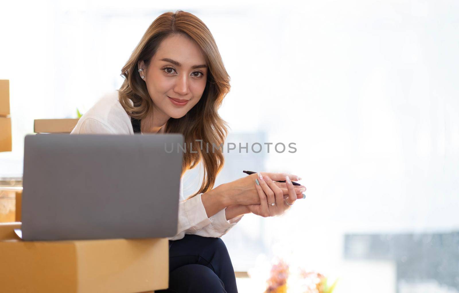 Portrait of Asian young woman SME working with a box at home the workplace.start-up small business owner, small business entrepreneur SME or freelance business online and delivery concept..