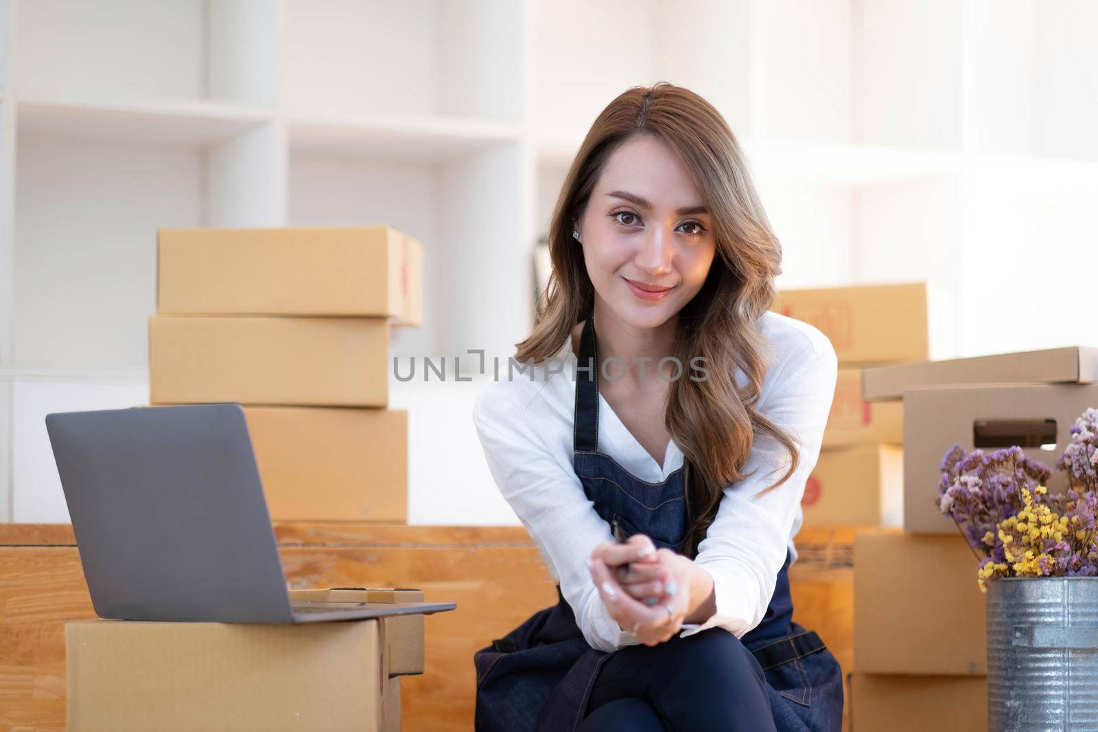 Portrait of Asian young woman SME working with a box at home the workplace.start-up small business owner, small business entrepreneur SME or freelance business online and delivery concept..