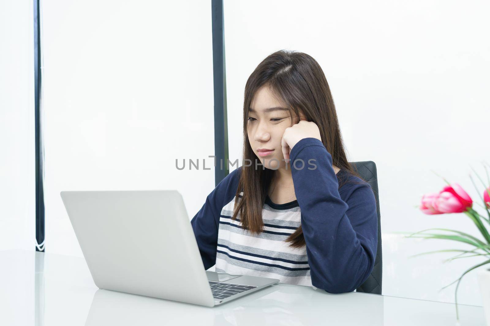 Young female student  sitting in living room and learning online by stoonn