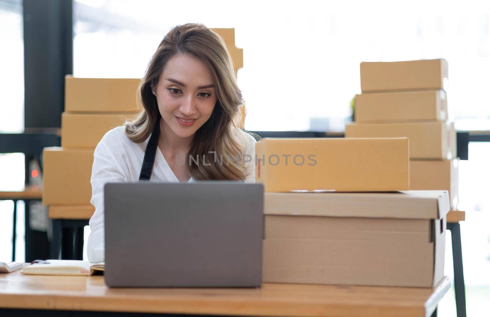 Portrait of Starting small businesses SME owners female entrepreneurs working on receipt box and check online orders to prepare to pack the boxes, sell to customers, sme business ideas online. by wichayada