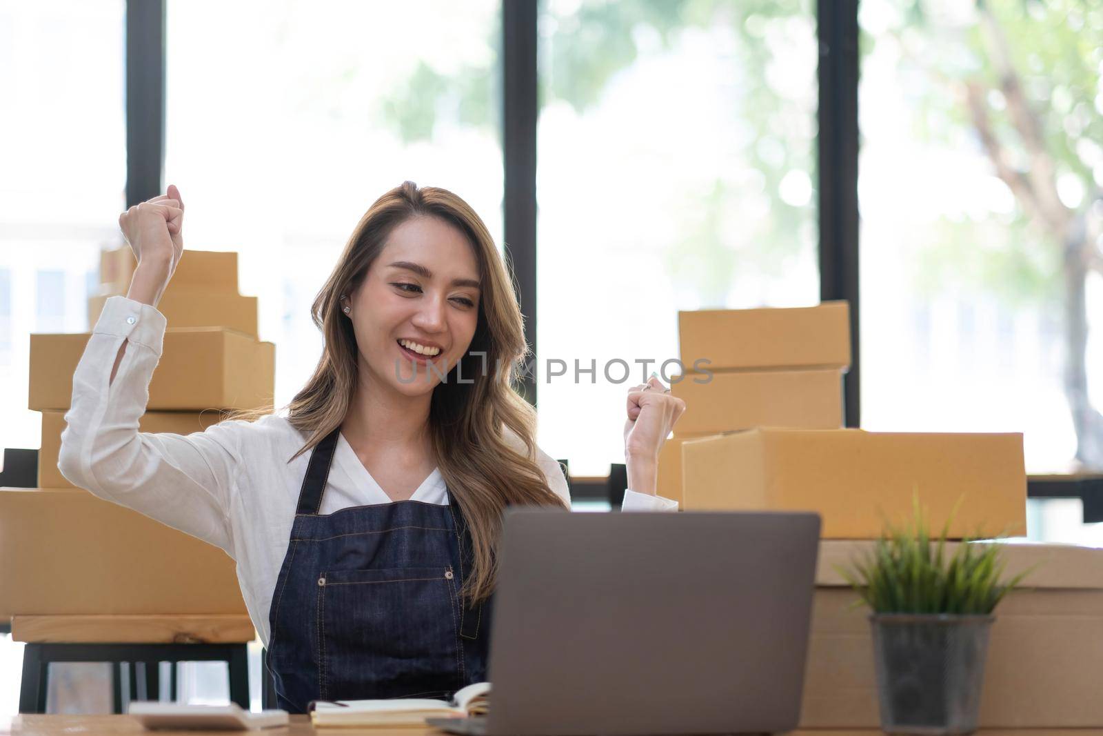 Portrait of Starting small businesses SME owners female entrepreneurs working on receipt box and check online orders to prepare to pack the boxes, sell to customers, SME business ideas online. by wichayada