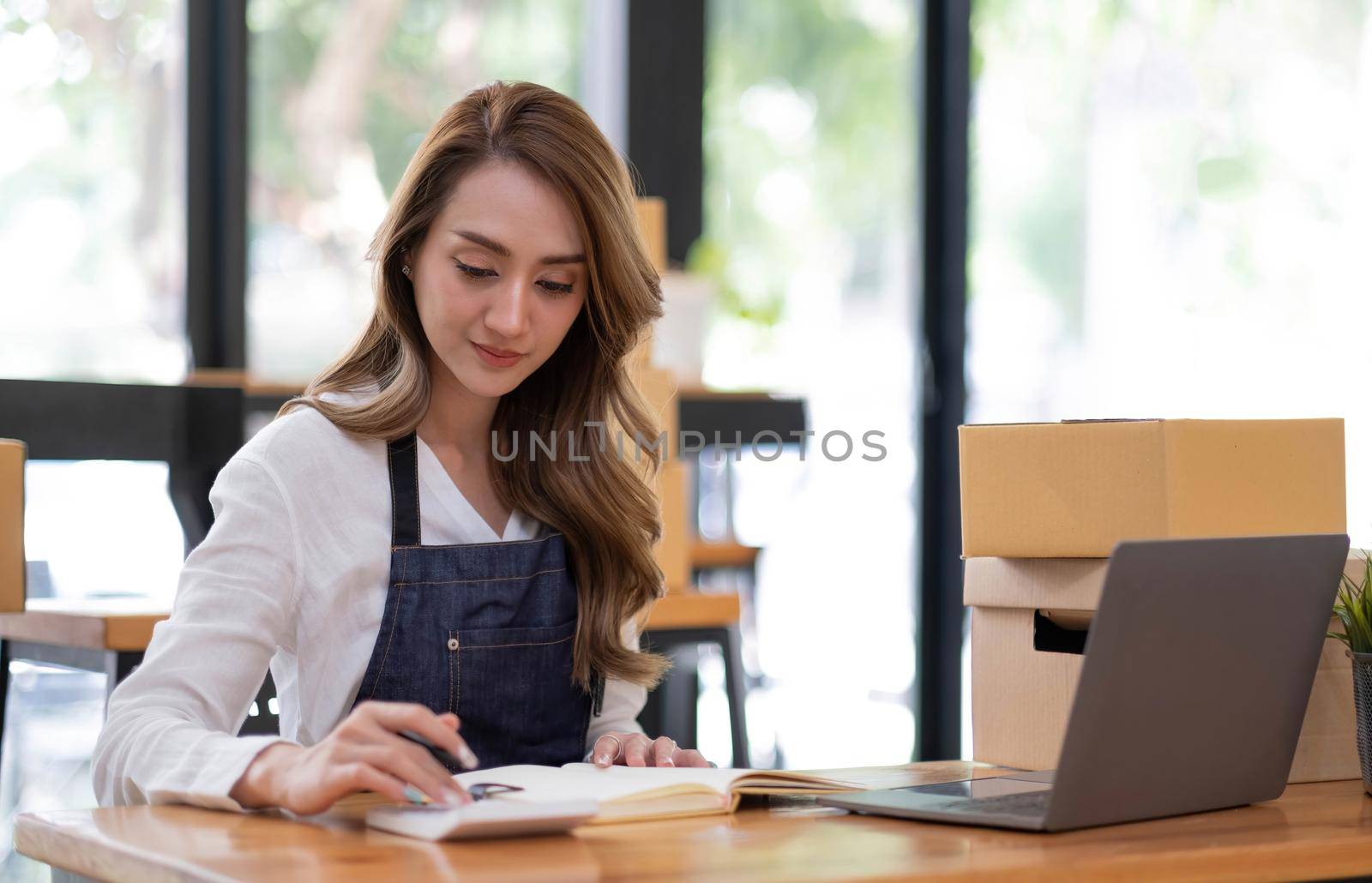 Portrait of Starting small businesses SME owners female entrepreneurs working on receipt box and check online orders to prepare to pack the boxes, sell to customers, sme business ideas online. by wichayada