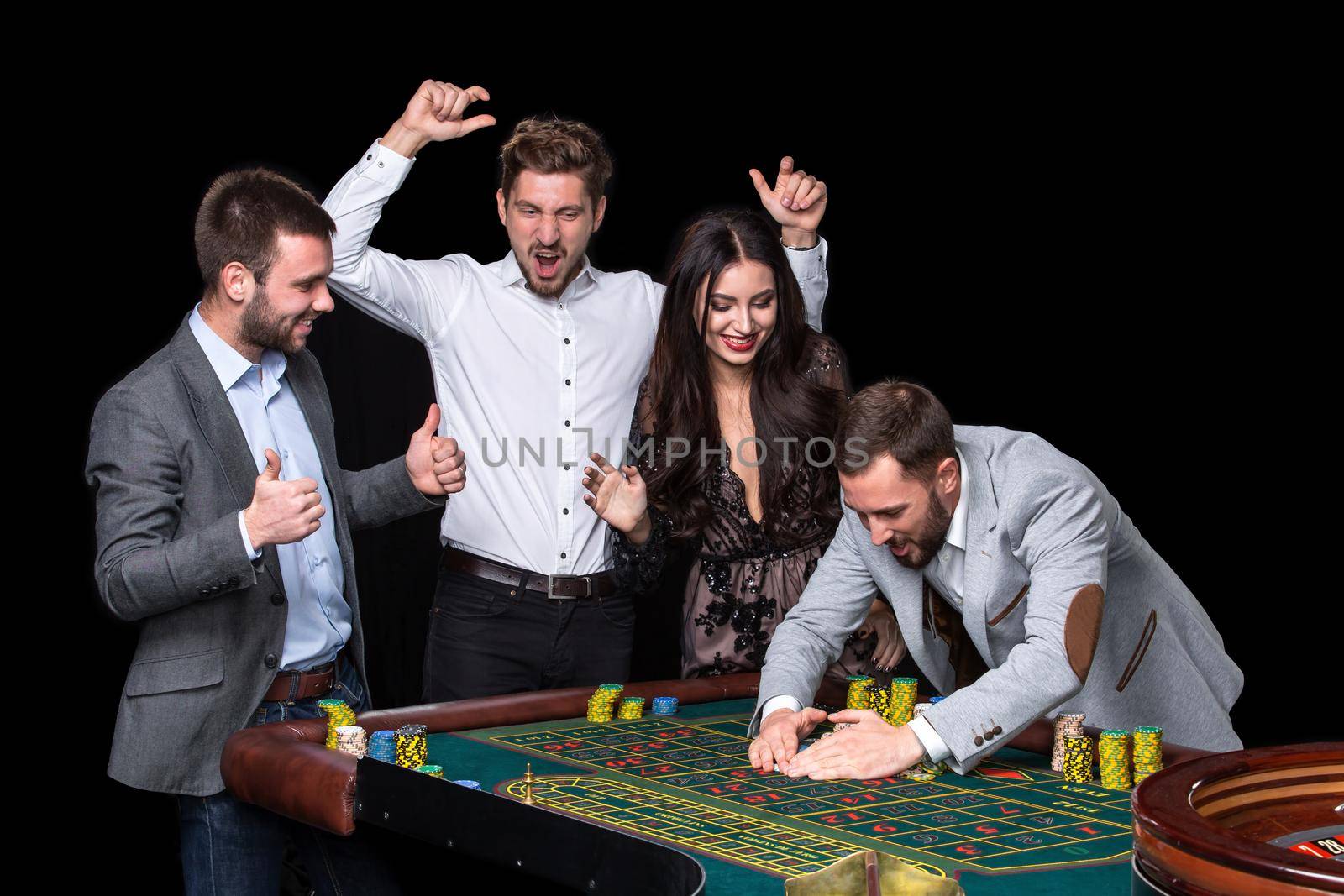 Upper class friends gambling in a casino. Roulette. Black background