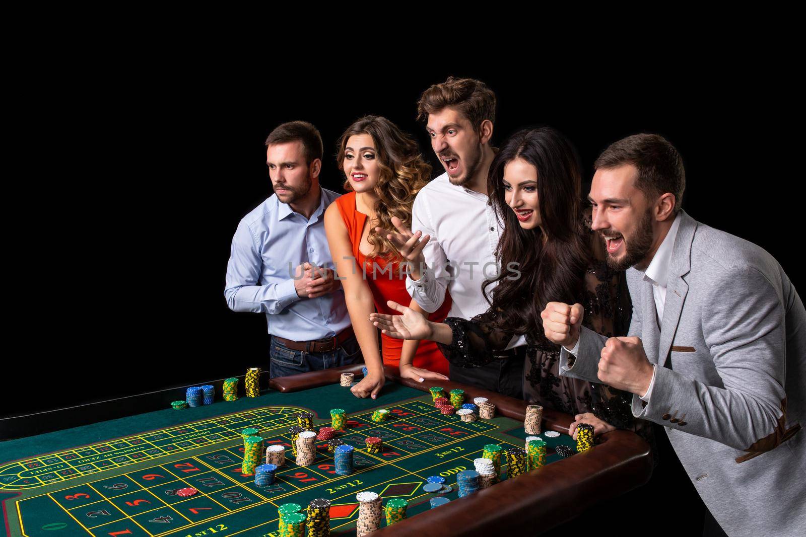 Group of young people behind roulette table in a casino by nazarovsergey