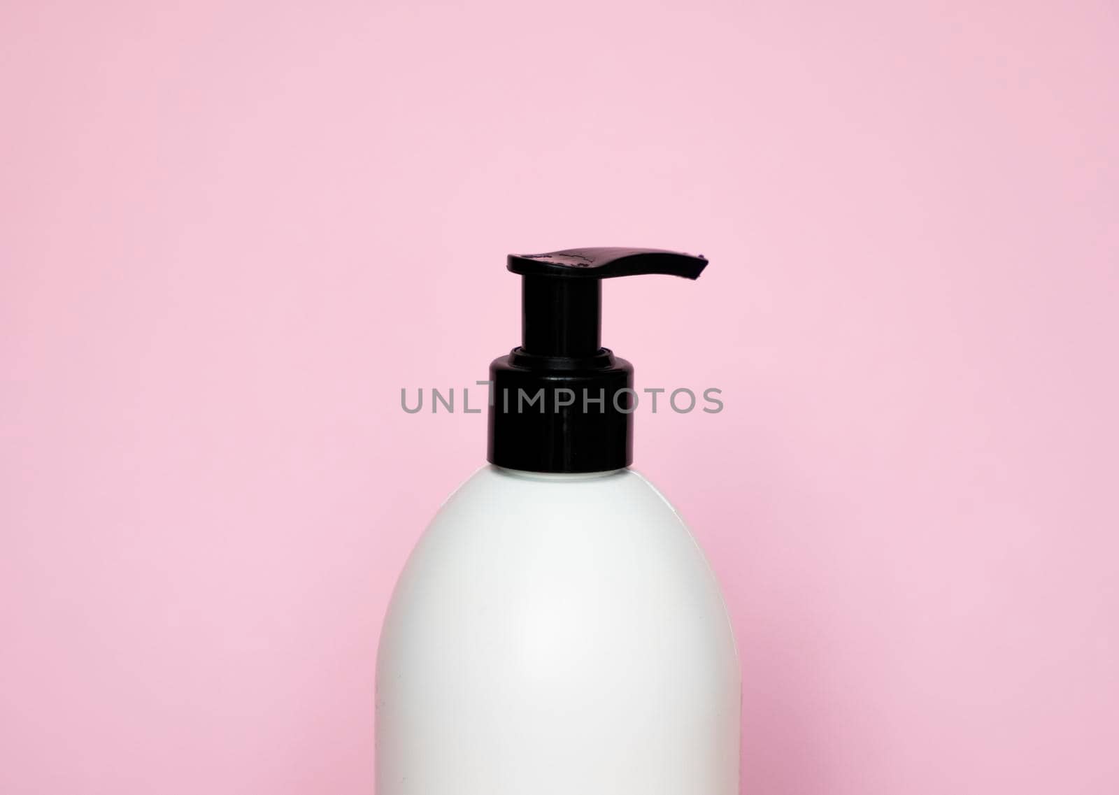 White plastic soap dispenser pump bottle isolated on pink background. Skin care lotion. Bathing essential product. Shampoo bottle. Bath and body lotion. Fine liquid hand wash. Bathroom accessories. by vovsht