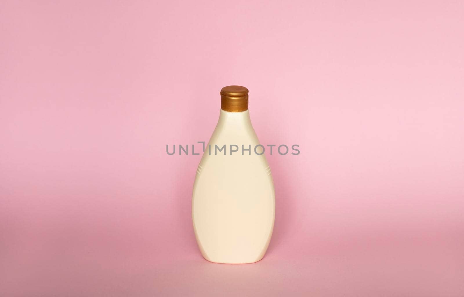 Beige plastic soap or shampoo bottle isolated on pink background. Skin care lotion. Bathing essential product. Shampoo bottle. Bath and body lotion. Fine liquid hand wash. Bathroom accessories. by vovsht