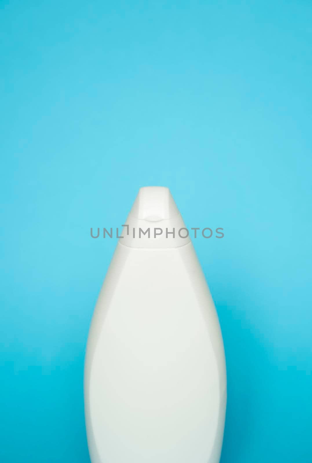 White plastic soap or shampoo bottle isolated on blue background. Skin care lotion. Bathing essential product. Shampoo bottle. Bath and body lotion. Fine liquid hand wash. Bathroom accessories. by vovsht
