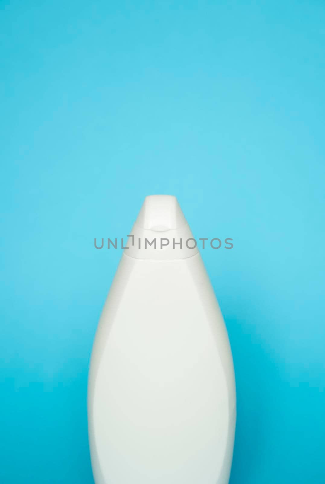 White plastic soap or shampoo bottle isolated on blue background. Skin care lotion. Bathing essential product. Shampoo bottle. Bath and body lotion. Fine liquid hand wash. Bathroom accessories