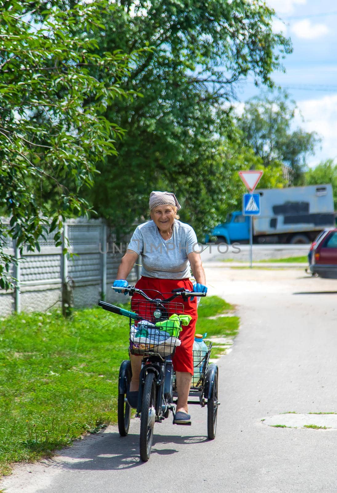 An old woman rides a bicycle. Selection focus. Nature.