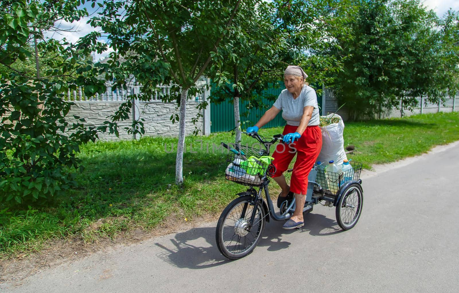 An old woman rides a bicycle. Selection focus. Nature.