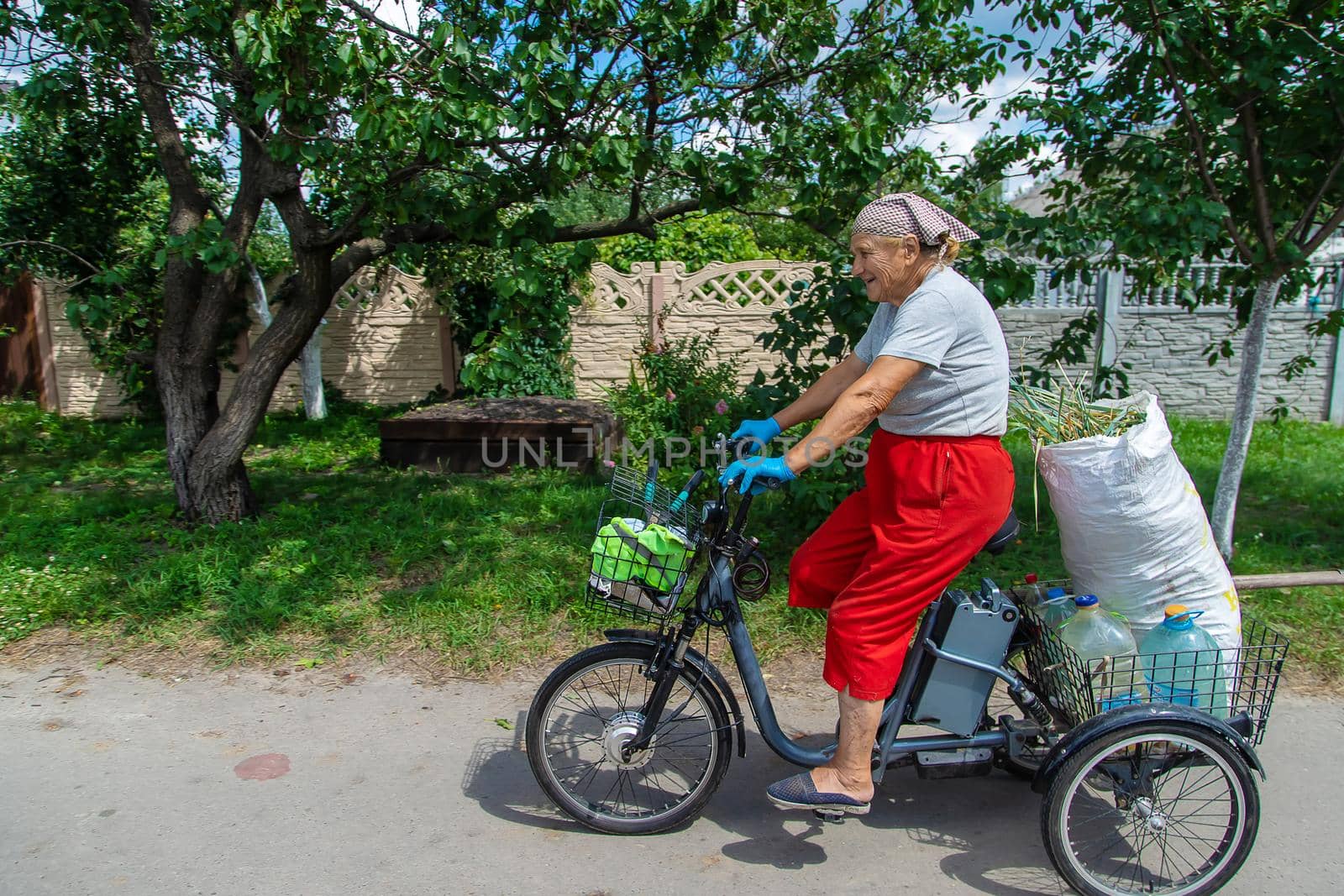 An old woman rides a bicycle. Selection focus. Nature.