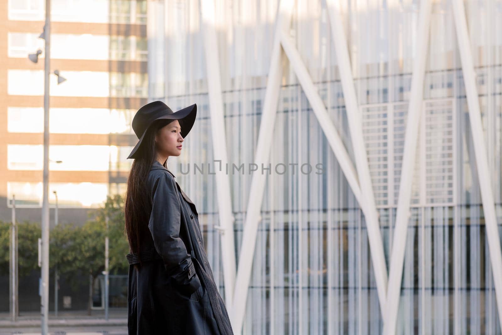 young asian woman in trench coat walking downtown by raulmelldo