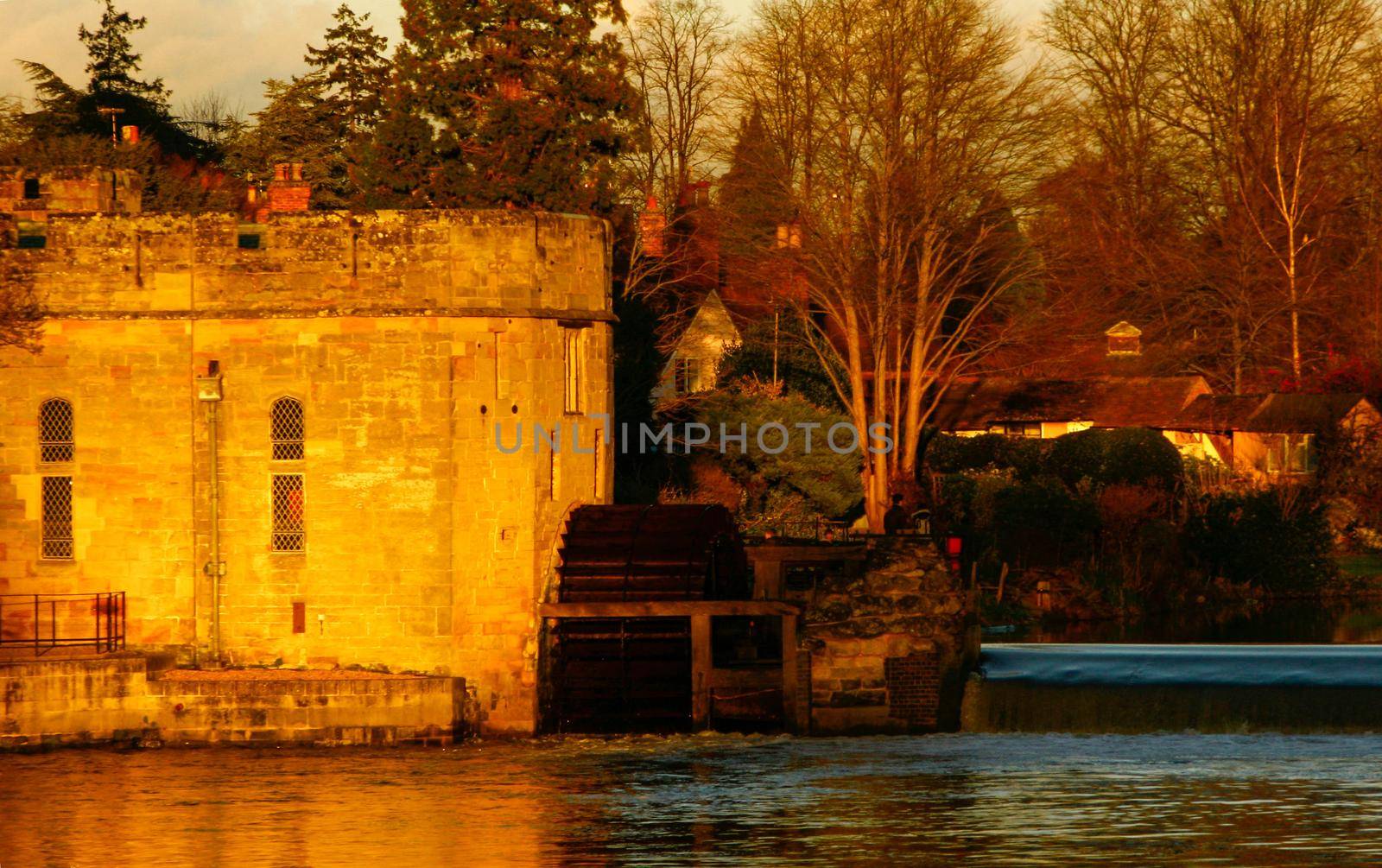 Ancient European medieval architectural building castle in golden autumn light with the blue sky background during autumn
