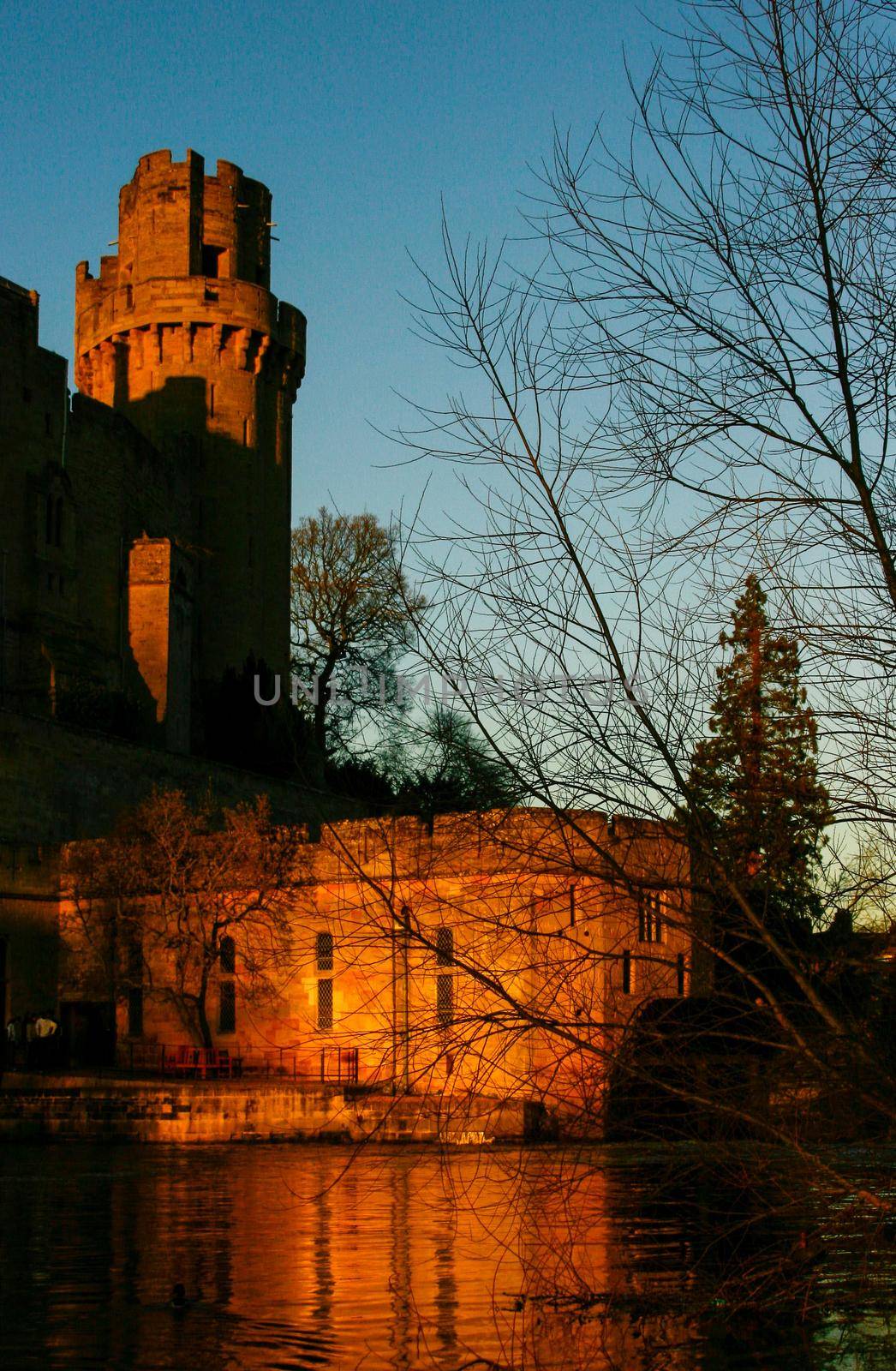 Ancient European medieval architectural building castle in golden autumn light with the blue sky background during autumn