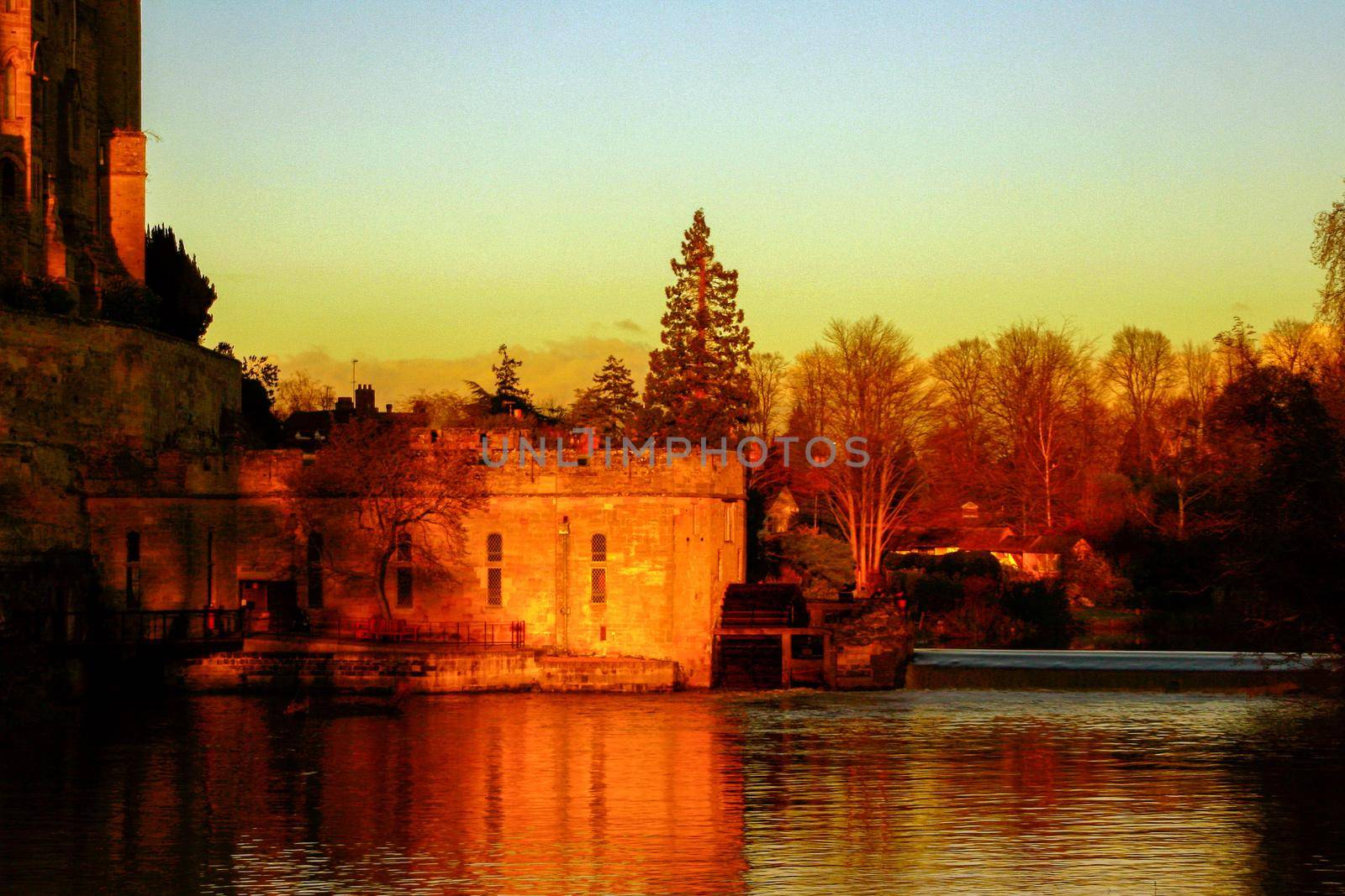 Ancient European medieval architectural building castle in golden autumn light with the blue sky background during autumn