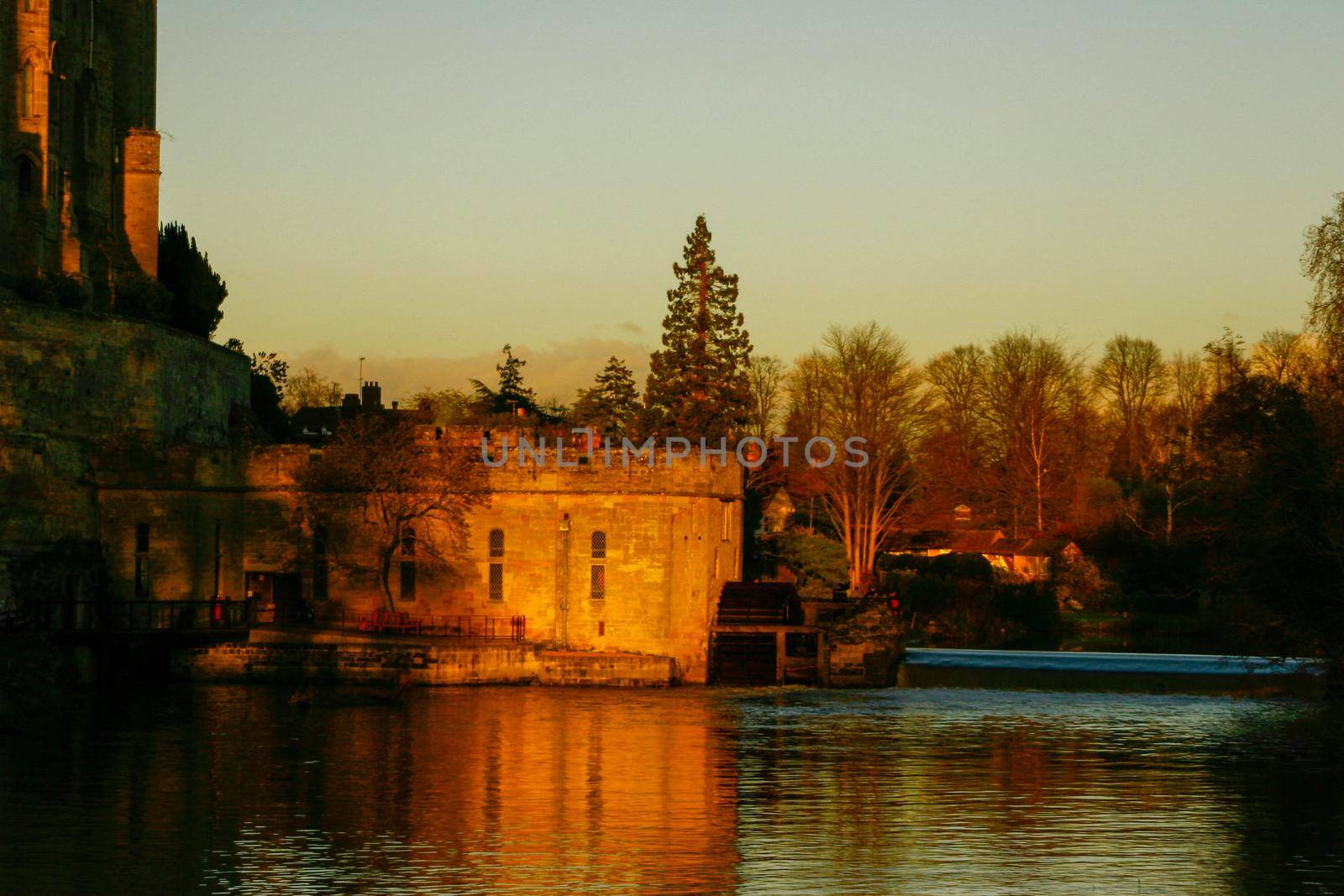 Ancient European medieval architectural building castle in golden autumn light with the blue sky background during autumn