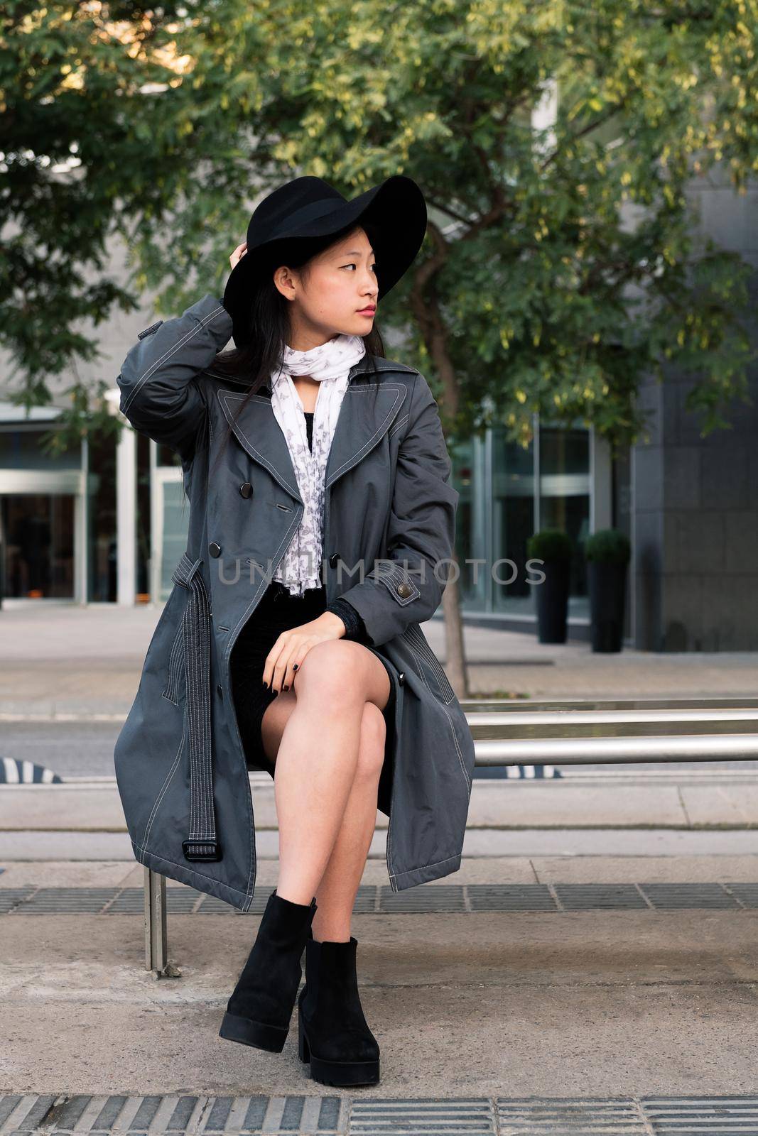elegant asian woman sitting waiting for the bus by raulmelldo