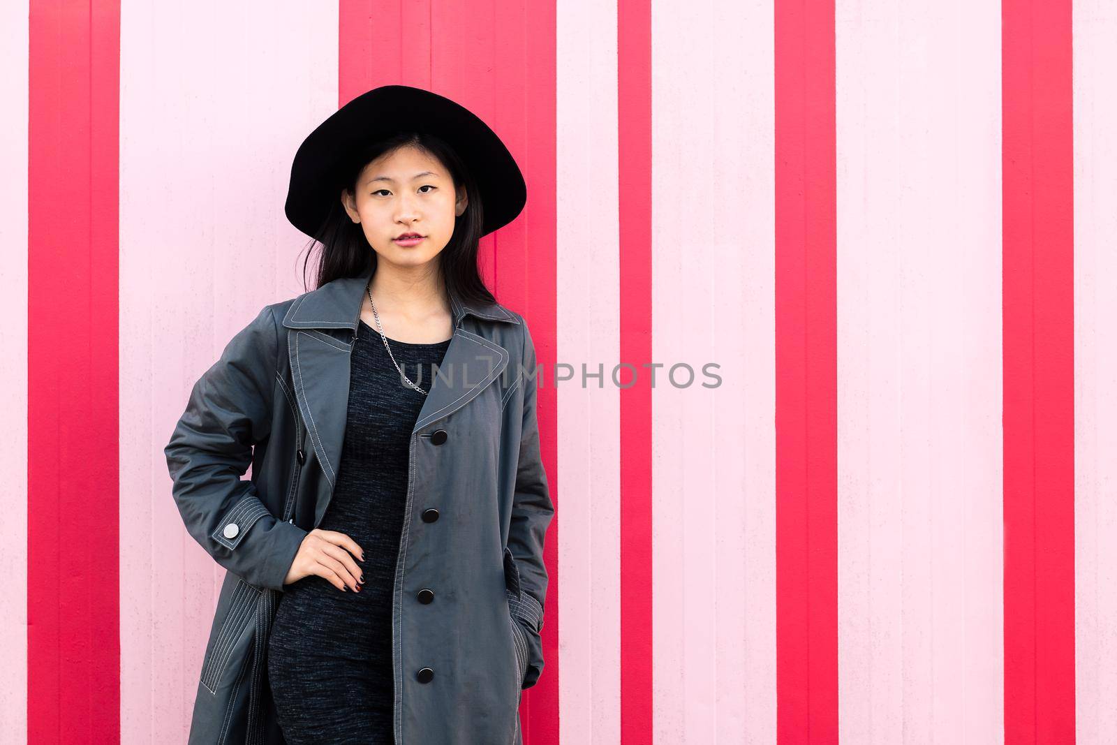 young beautiful classy asian girl posing in a pink background, concept of elegance and fashion lifestyle, copy space for text