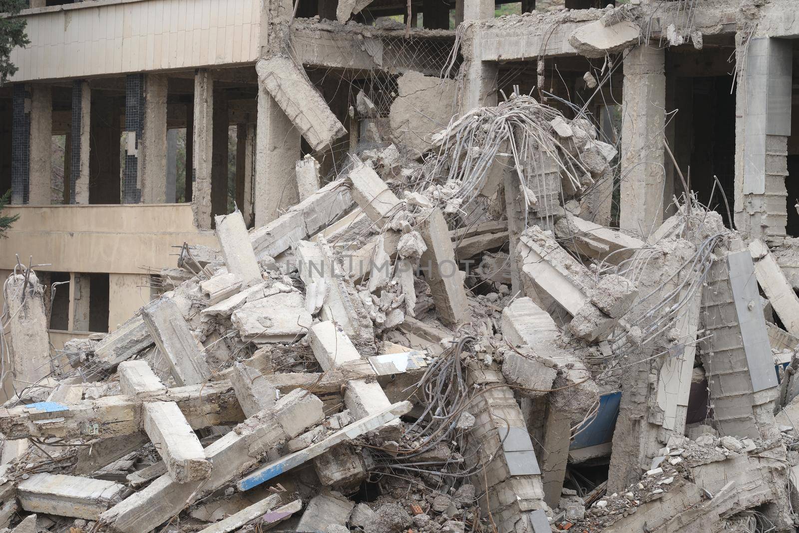 Industrial concrete building destroyed by an earthquake. Disaster war debris dust and destroyed buildings concept