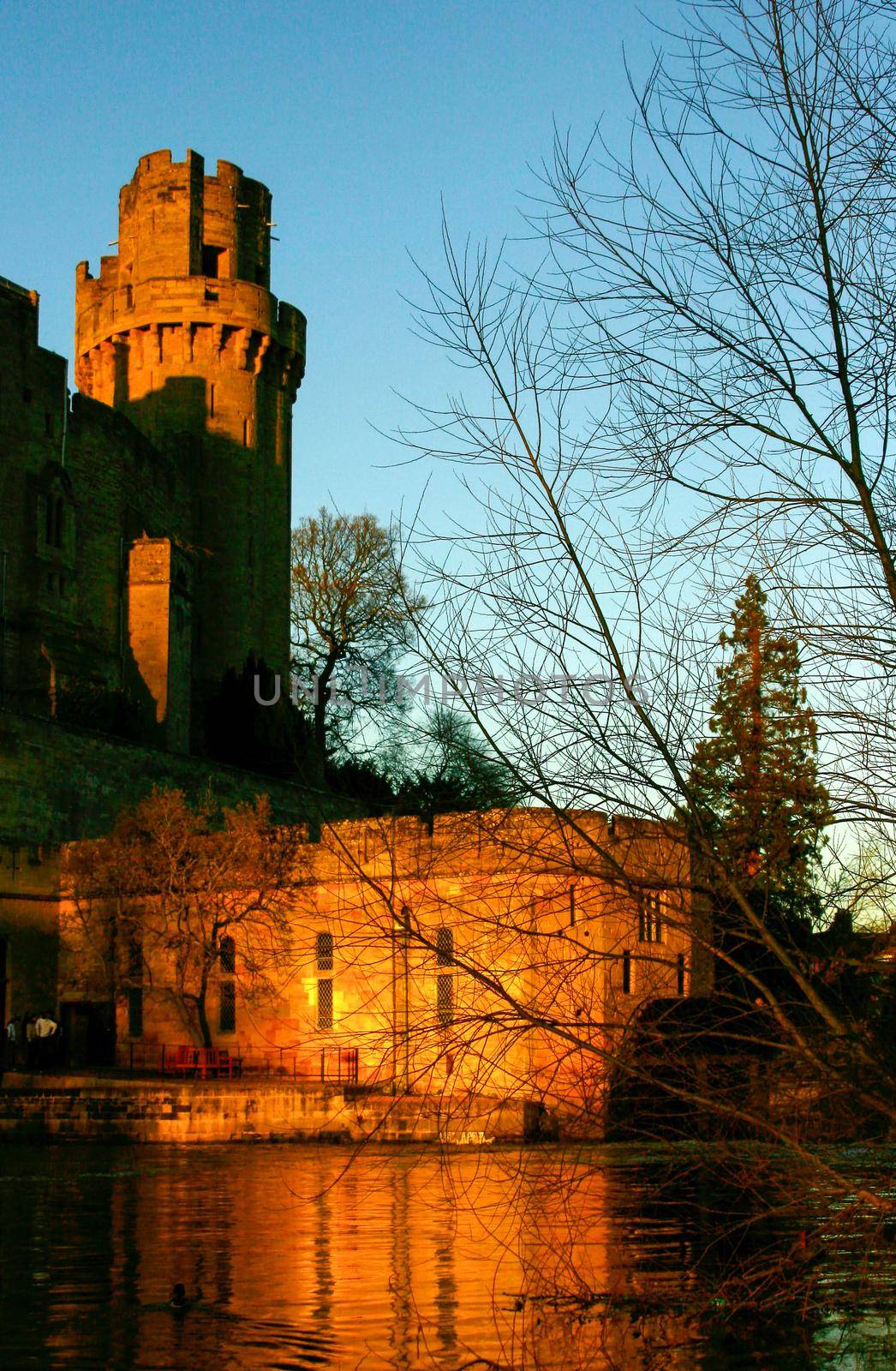 Ancient European medieval architectural building castle in golden autumn light with the blue sky background during autumn