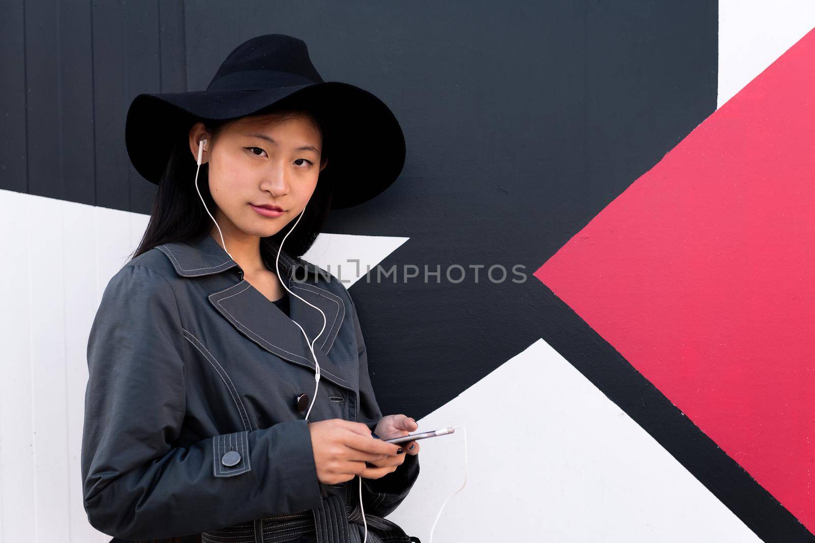classy chinese woman with earphones and phone by raulmelldo