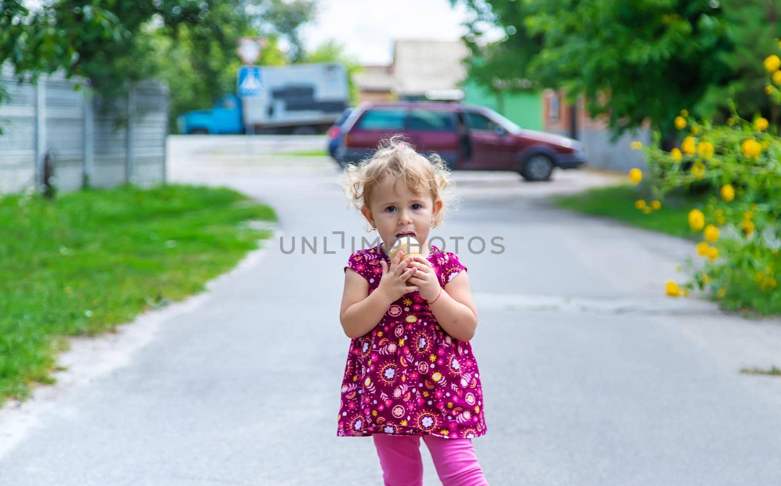 The child eats ice cream on the street. Selective focus. Food.