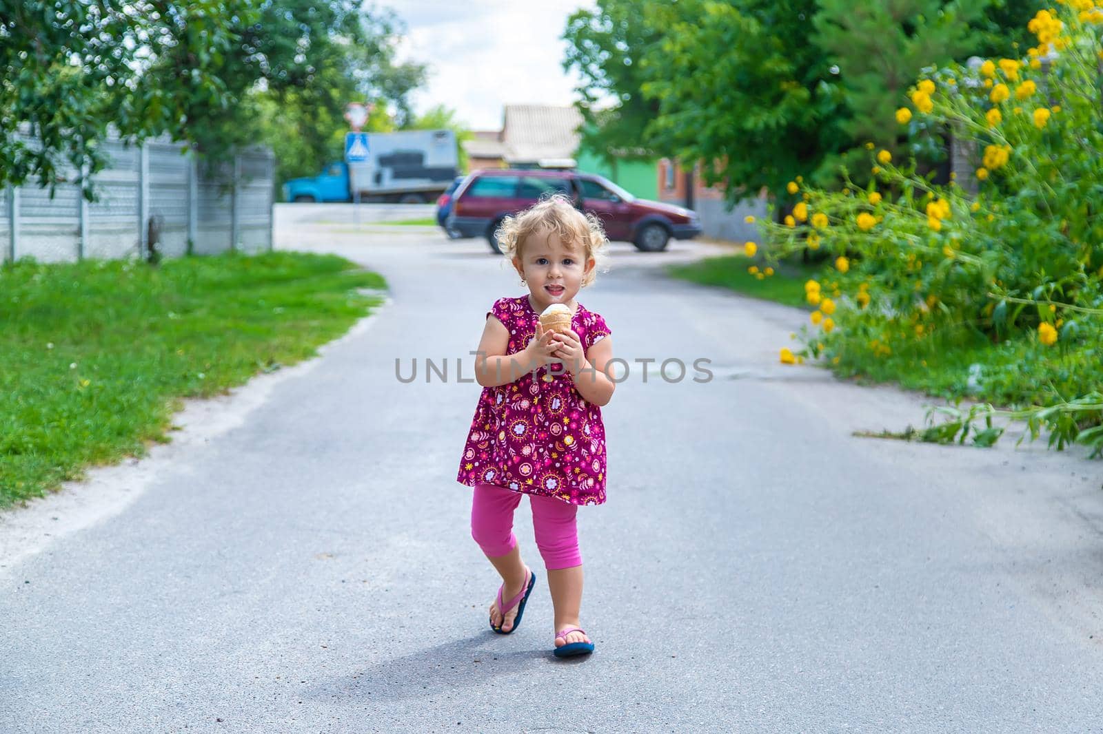 The child eats ice cream on the street. Selective focus. by yanadjana