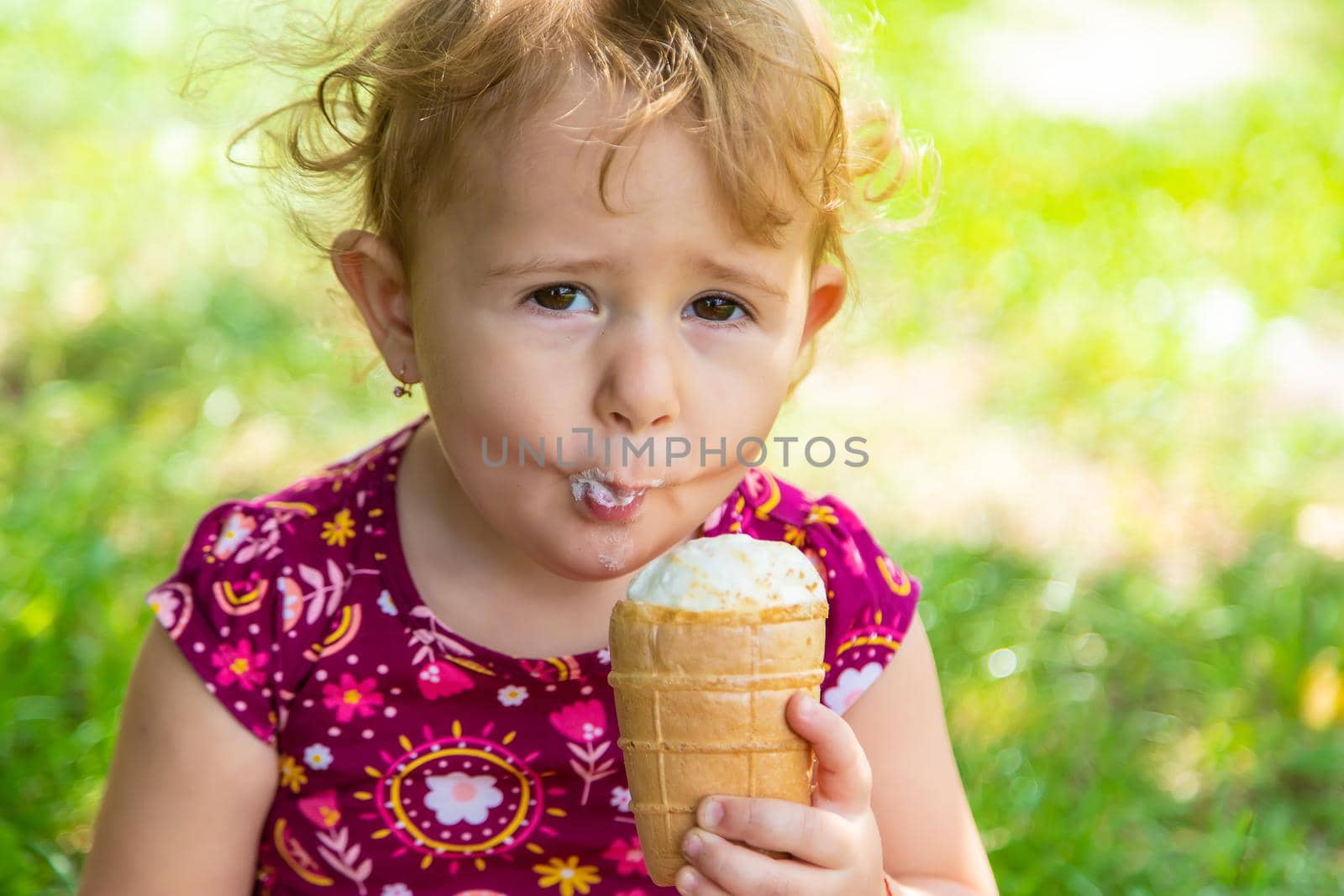 The child eats ice cream on the street. Selective focus. Food.