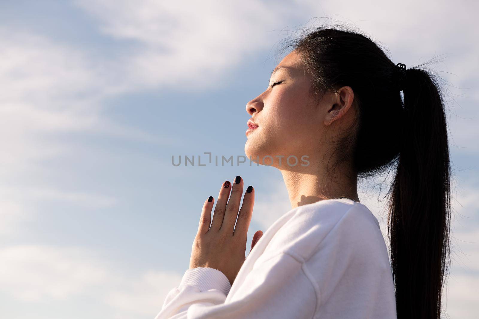 portrait of a young asian woman meditating at sunrise, relaxation and mental health concept, copyspace for text