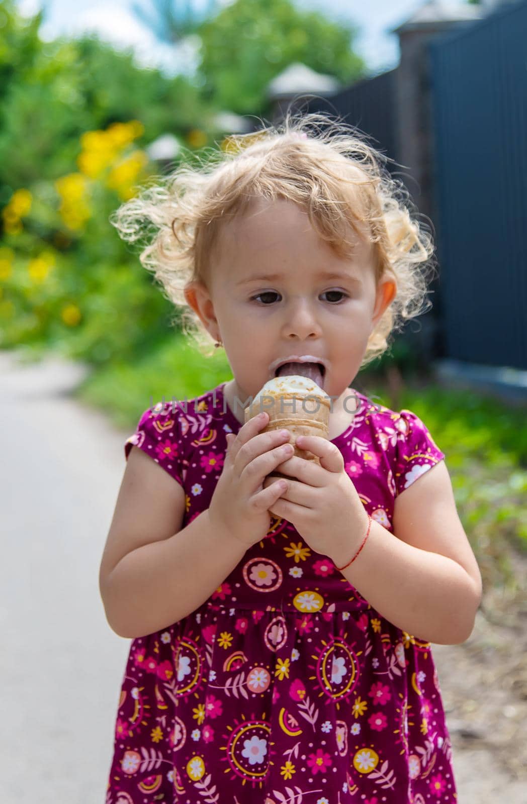 The child eats ice cream on the street. Selective focus. Food.