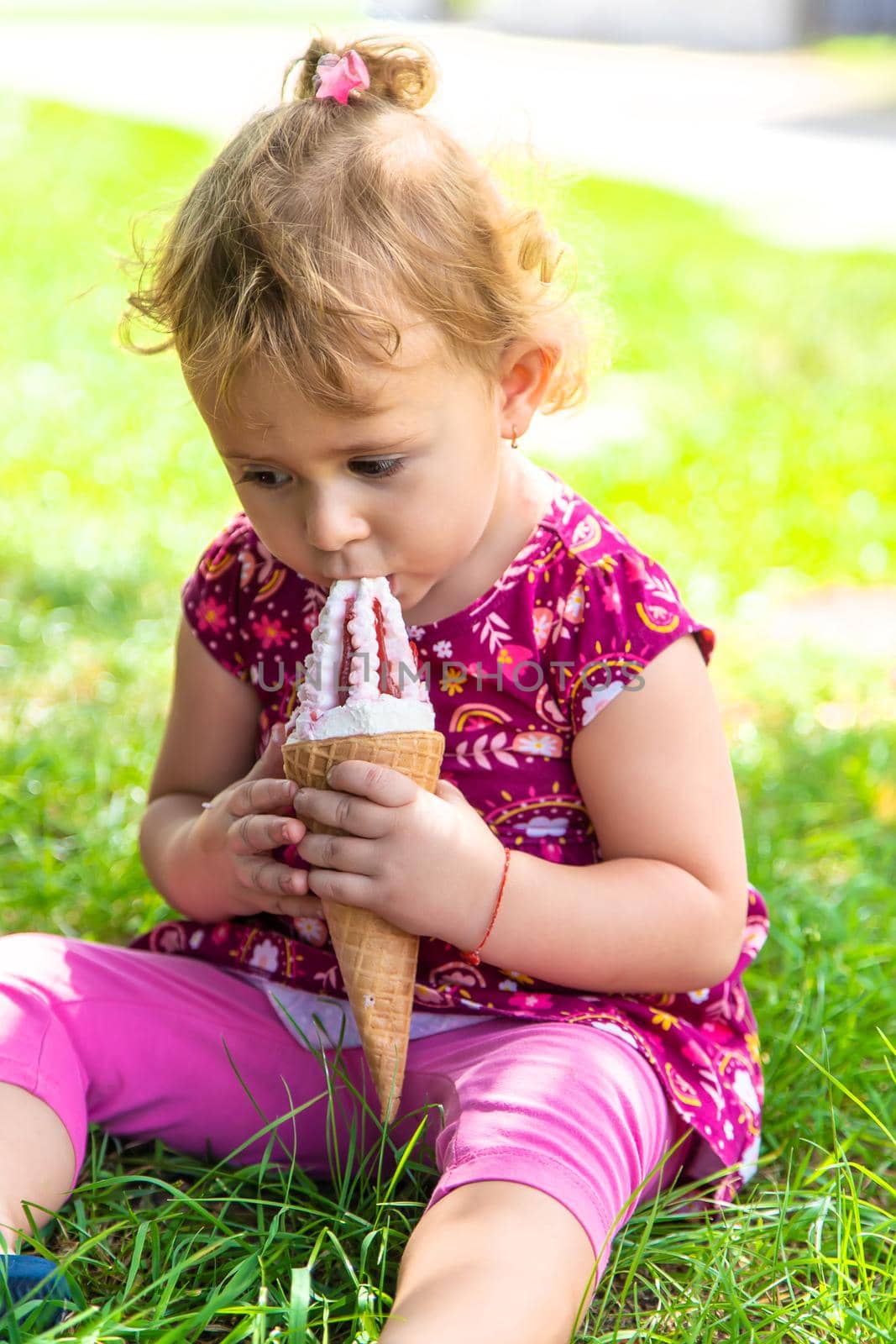 The child eats ice cream on the street. Selective focus. by yanadjana