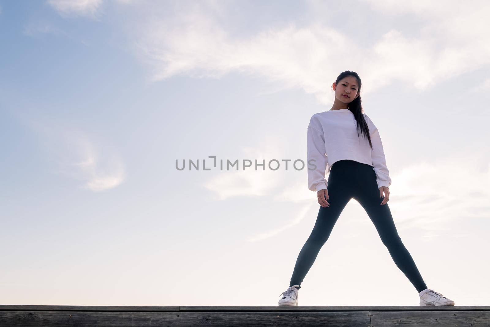 asian sportswoman looking defiant at camera by raulmelldo