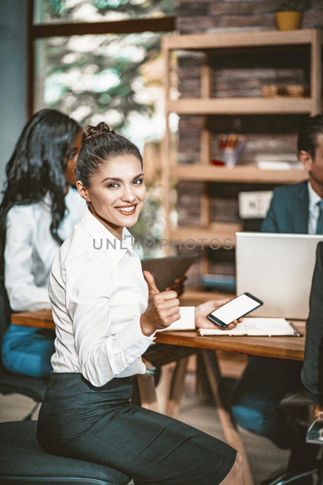 Smiling businesswoman shows Thumbs Up Gesture Sitting At Meeting Table, Selective Focus On Female Face, Portrait Of Cheerful Business Lady In Formalwear Showing Big Thumb In Approval, Toned Image