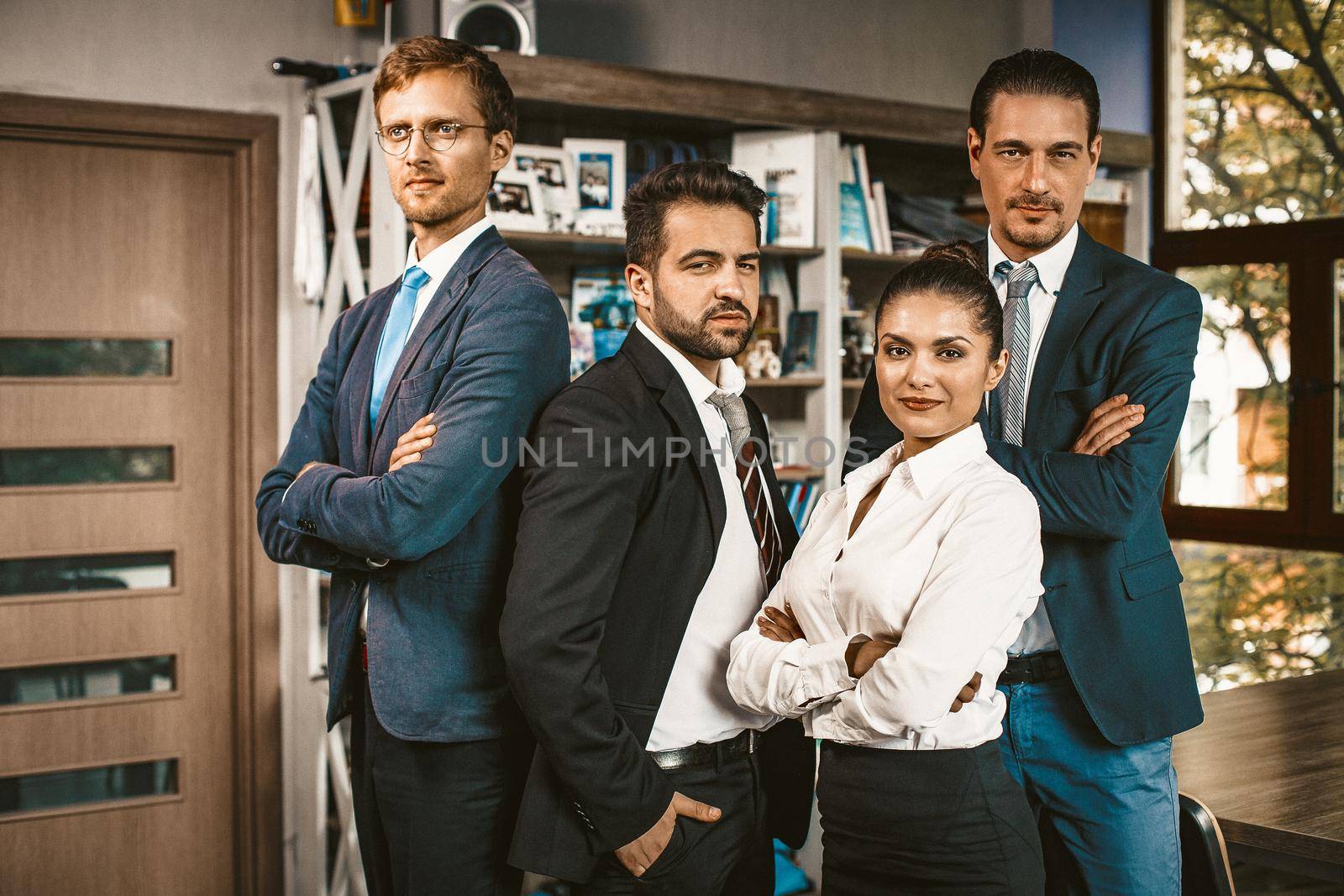 Woman chief And Her Male Team Poses Standing Together In Modern Office, Attractive Well-Dressed Successful People Stand Looking At Camera, Business Portrait Concept, Toned Image