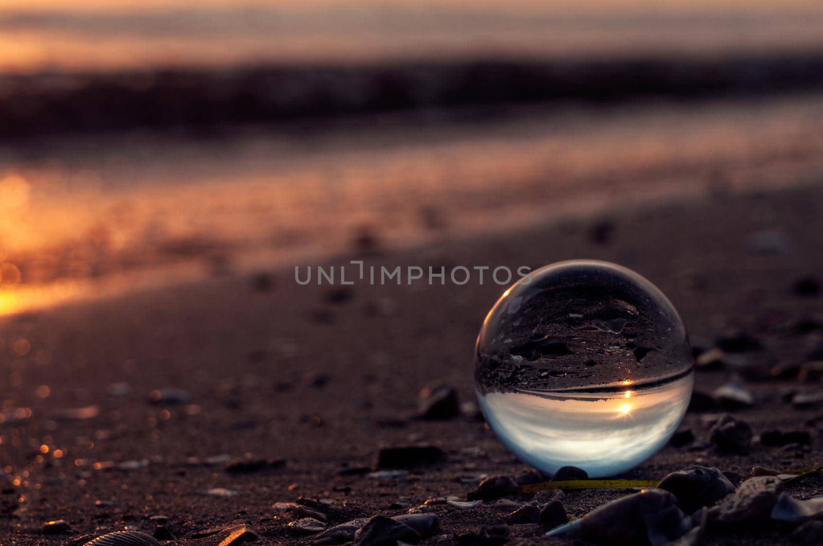 Crystall glass ball on the sea sand