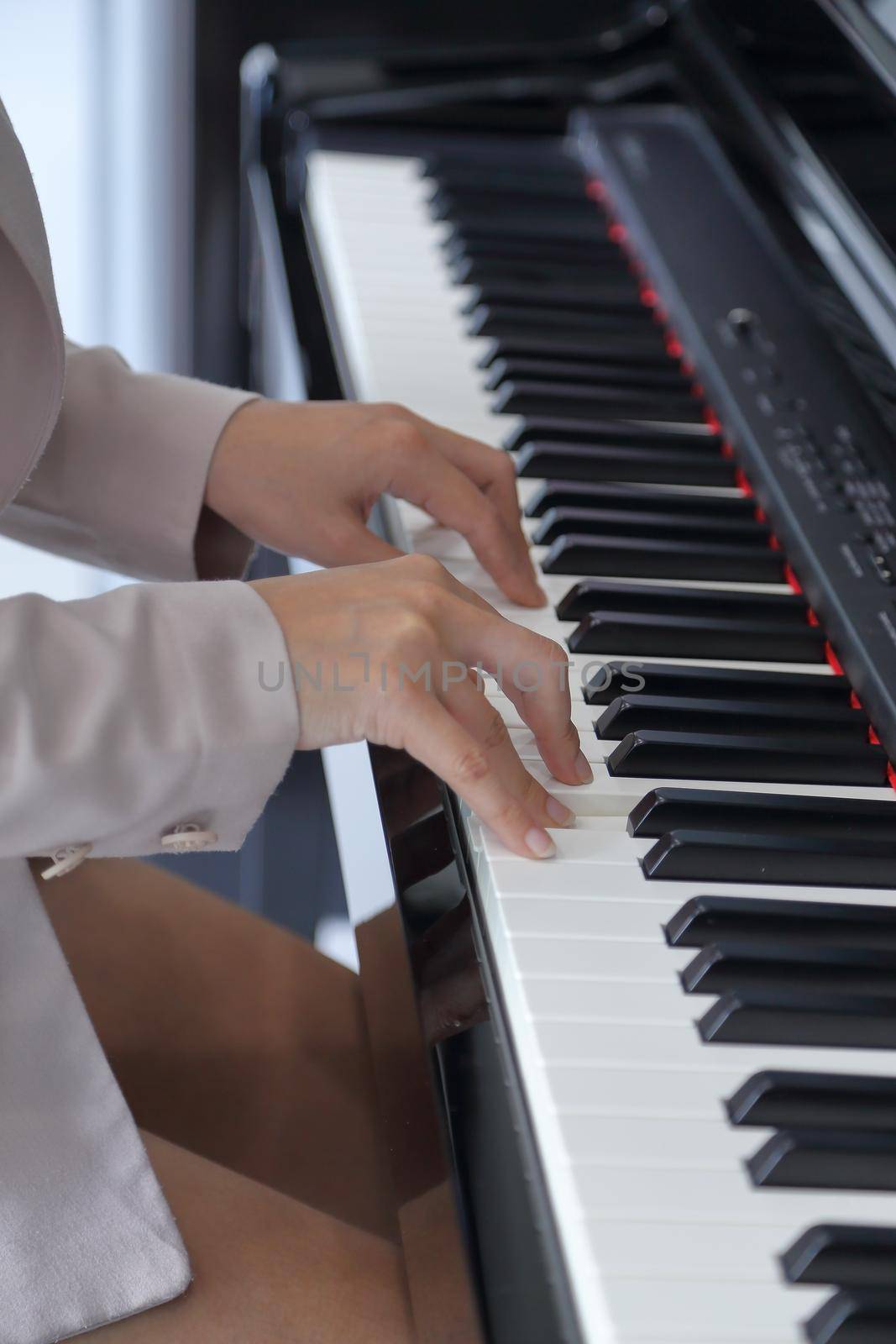 hands of a young woman playing piano