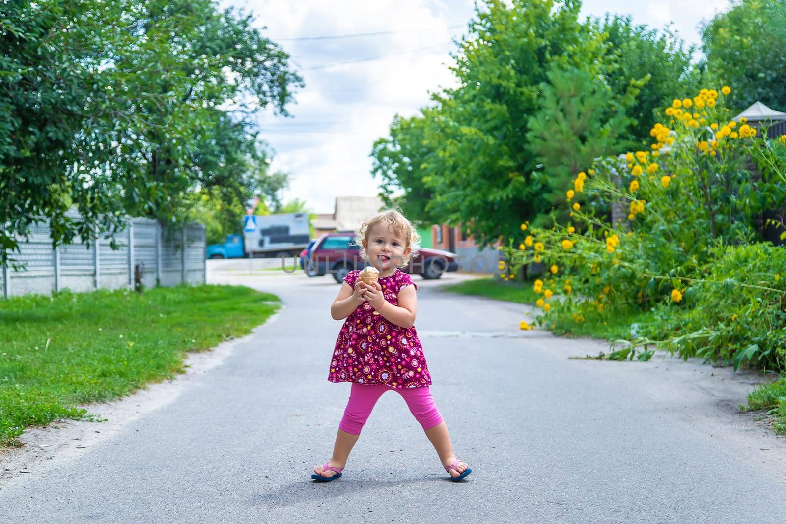 The child eats ice cream on the street. Selective focus. by yanadjana