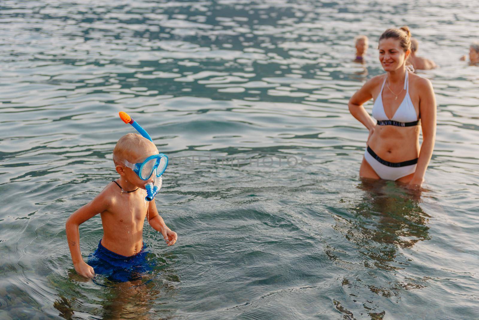 Cute happy little boy swimming and snorking in the sea. Child wearing snorkeling mask diving underwater, little boy enjoy swim underwater on tropical resort