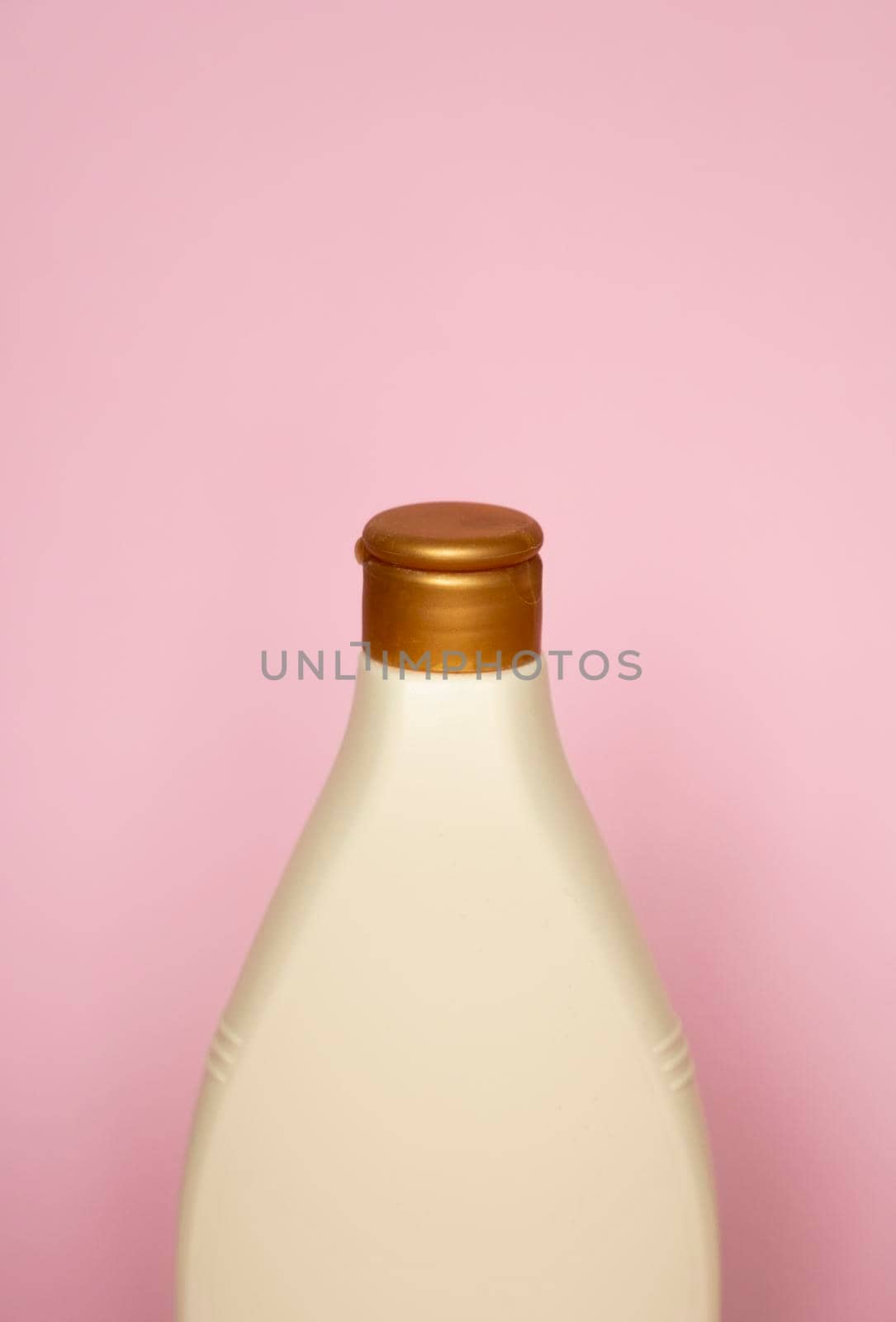 Beige plastic soap or shampoo bottle isolated on pink background. Skin care lotion. Bathing essential product. Shampoo bottle. Bath and body lotion. Fine liquid hand wash. Bathroom accessories
