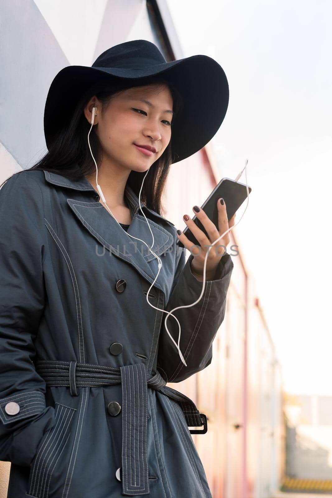 asian woman with earphones making a video call by raulmelldo