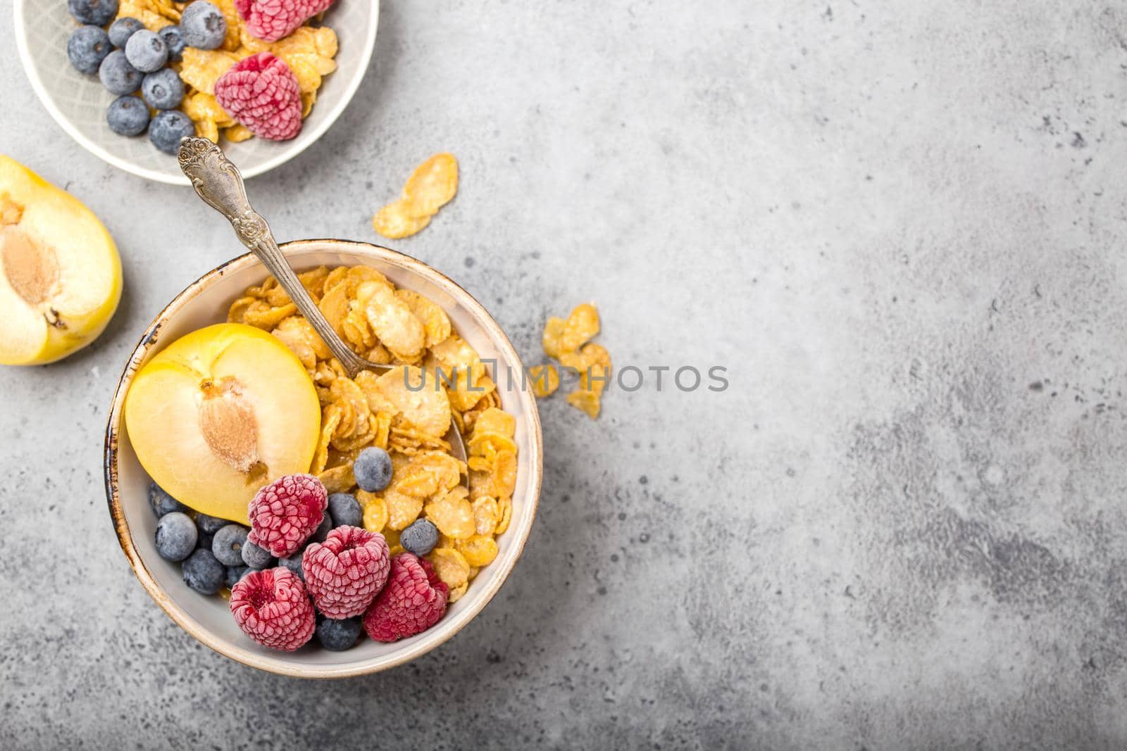 Healthy breakfast bowl, cereals, fresh fruit, berries on table. Clean eating, diet concept. Top view. Healthy bowl with cereals, raspberries, blueberries, plum. Space for text. Selective focus.