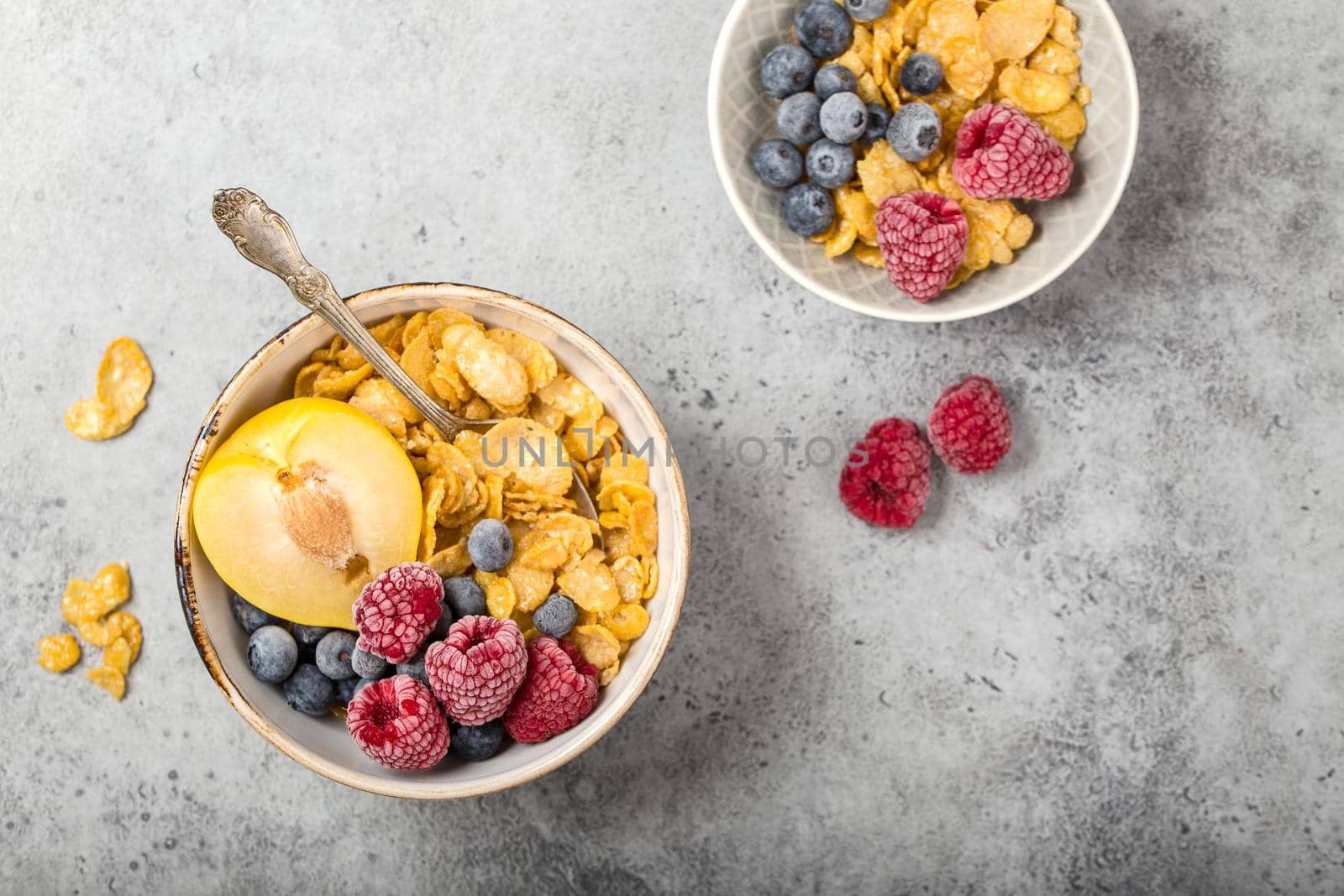 Healthy breakfast bowl, cereals, fresh fruit, berries on table. Clean eating, diet concept. Top view. Healthy bowl with cereals, raspberries, blueberries, plum. Space for text. Selective focus.