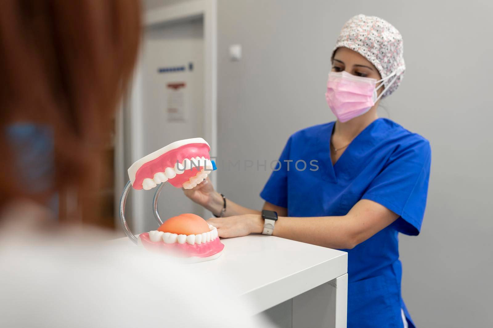 A female dentist teaching one of her clients the correct way of brushing her teeth at the hall of the dental clinic