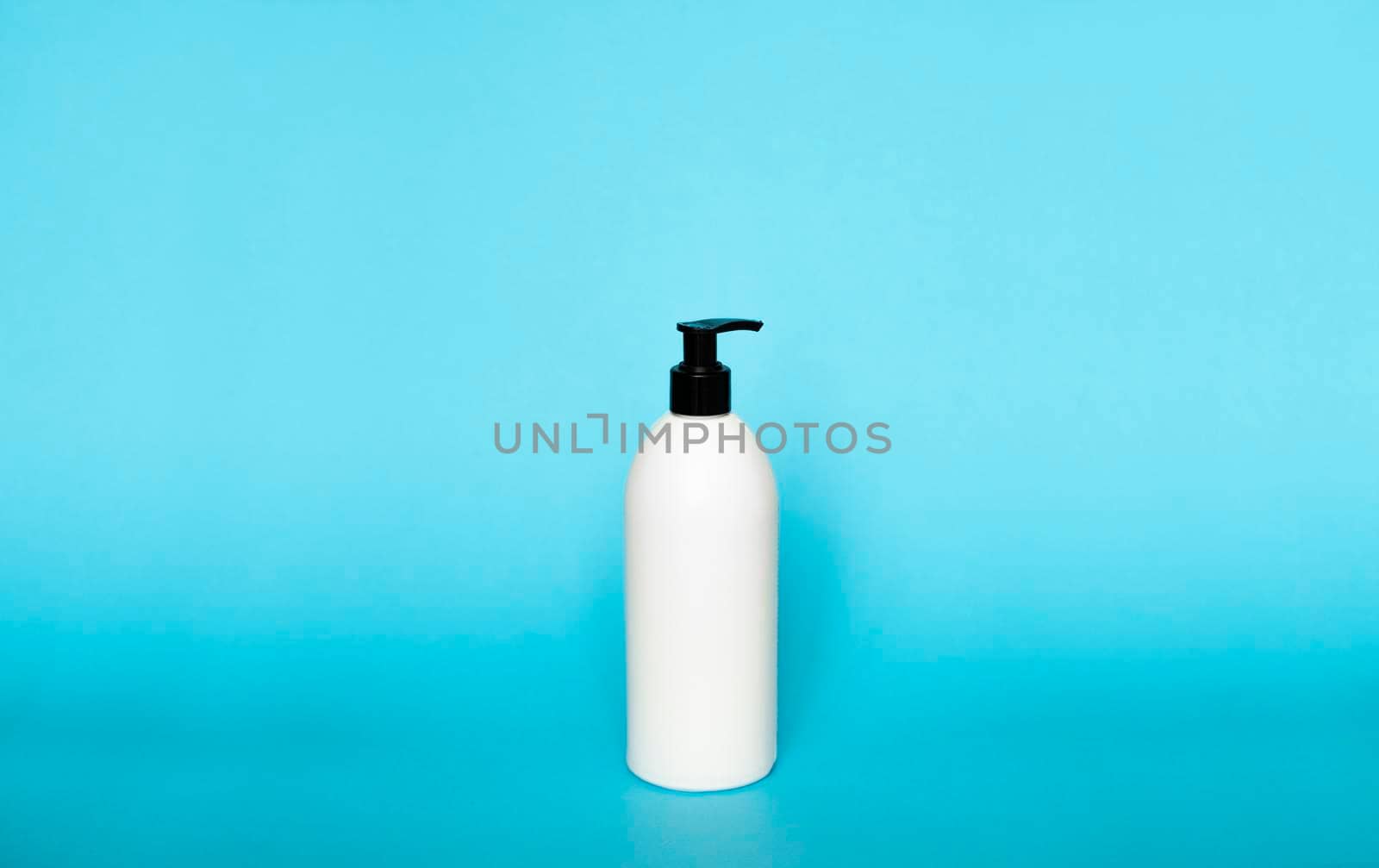 White plastic soap dispenser pump bottle isolated on blue background. Skin care lotion. Bathing essential product. Shampoo bottle. Bath and body lotion. Fine liquid hand wash. Bathroom accessories. by vovsht