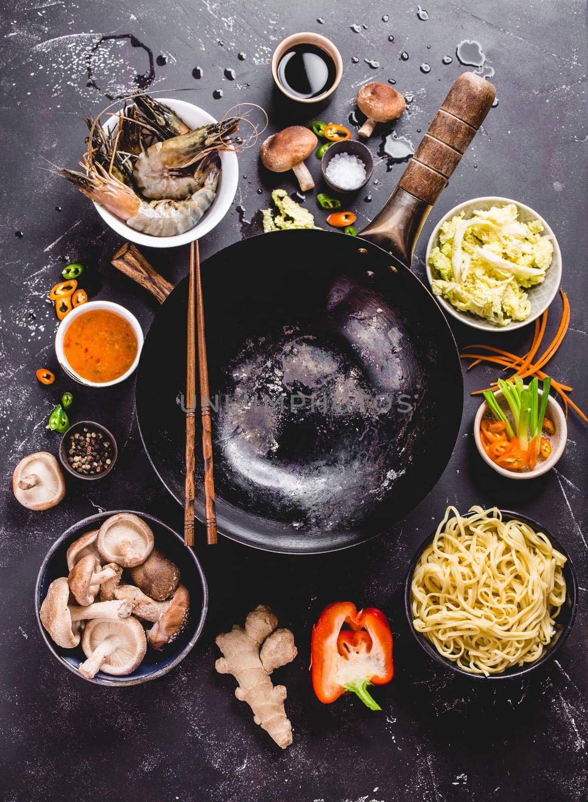 Asian food cooking concept. Empty wok pan, noodles, vegetables stir fry, shrimps, sauces, chopsticks. Asian/Chinese food. Top view. Ingredients for making Asian/Chinese dinner. Chinese noodles