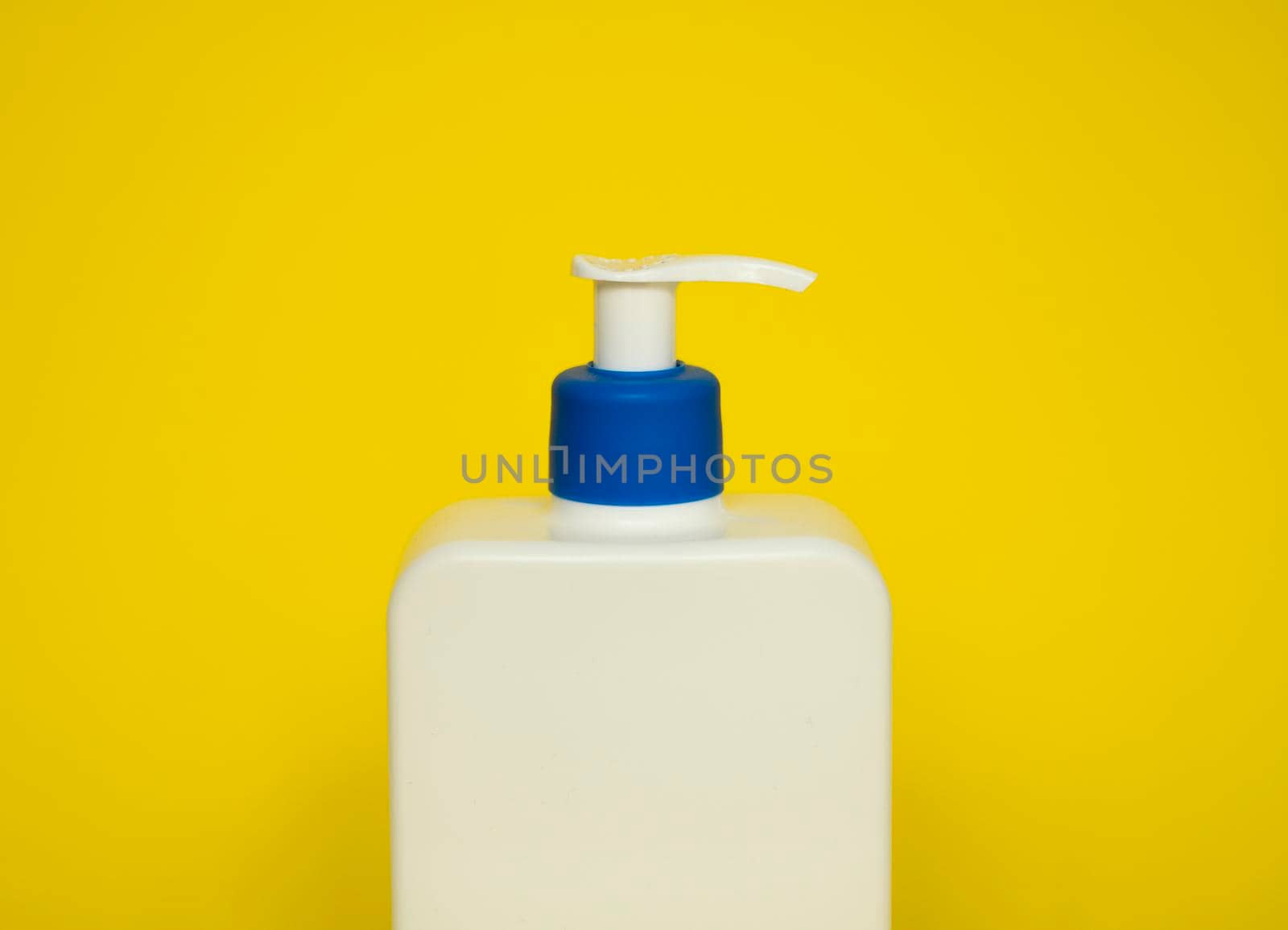 White plastic soap or shampoo dispenser pump bottle isolated on blue background. Skin care lotion. Bathing essential product. Shampoo bottle. Bath and body lotion. Fine liquid hand wash. by vovsht