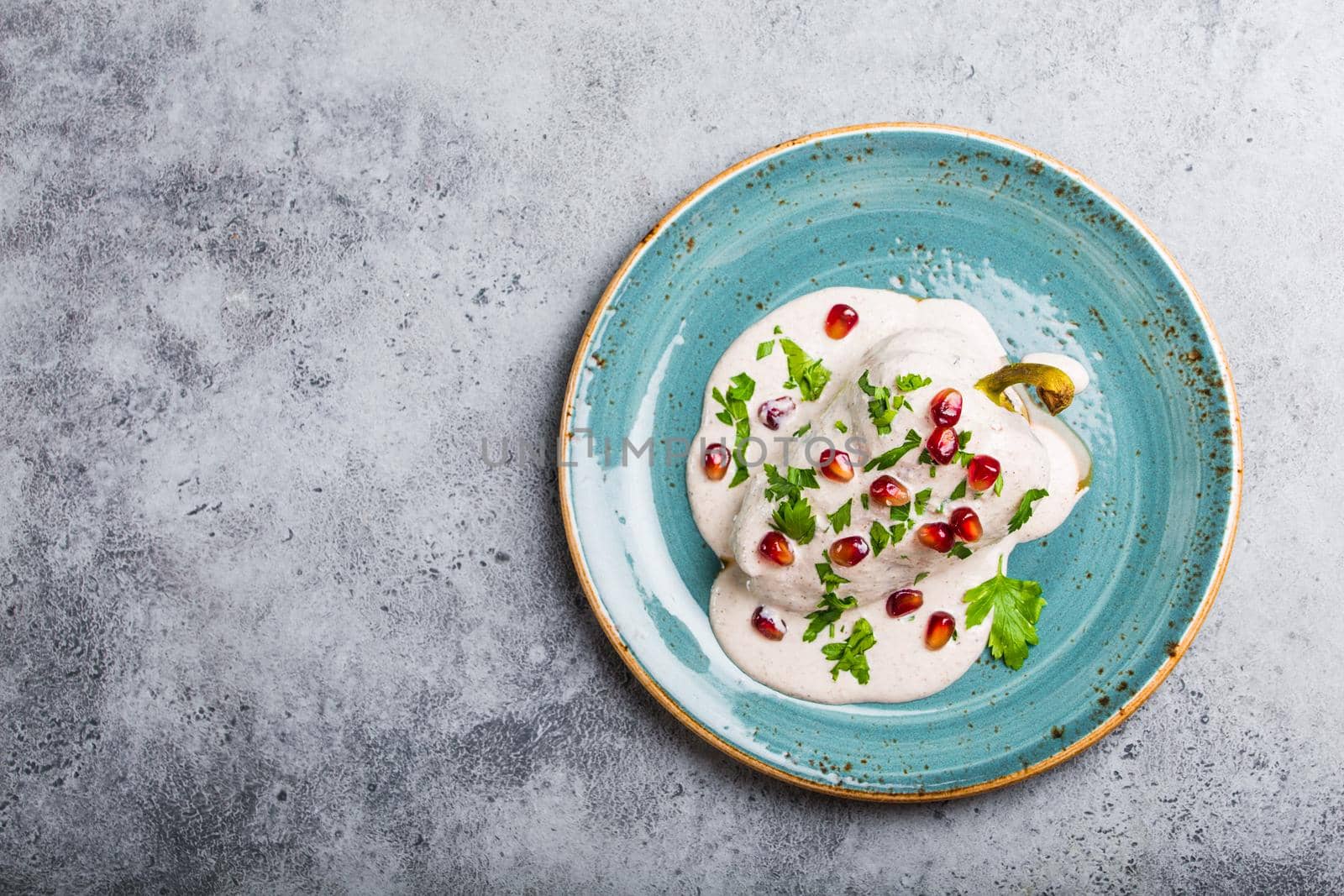 Top view of chiles en nogada, traditional festive dish on Mexican Independence Day. Peppers chili with walnut sauce, appetizer usual for Mexico, for celebration and grand food fiesta. Space for text