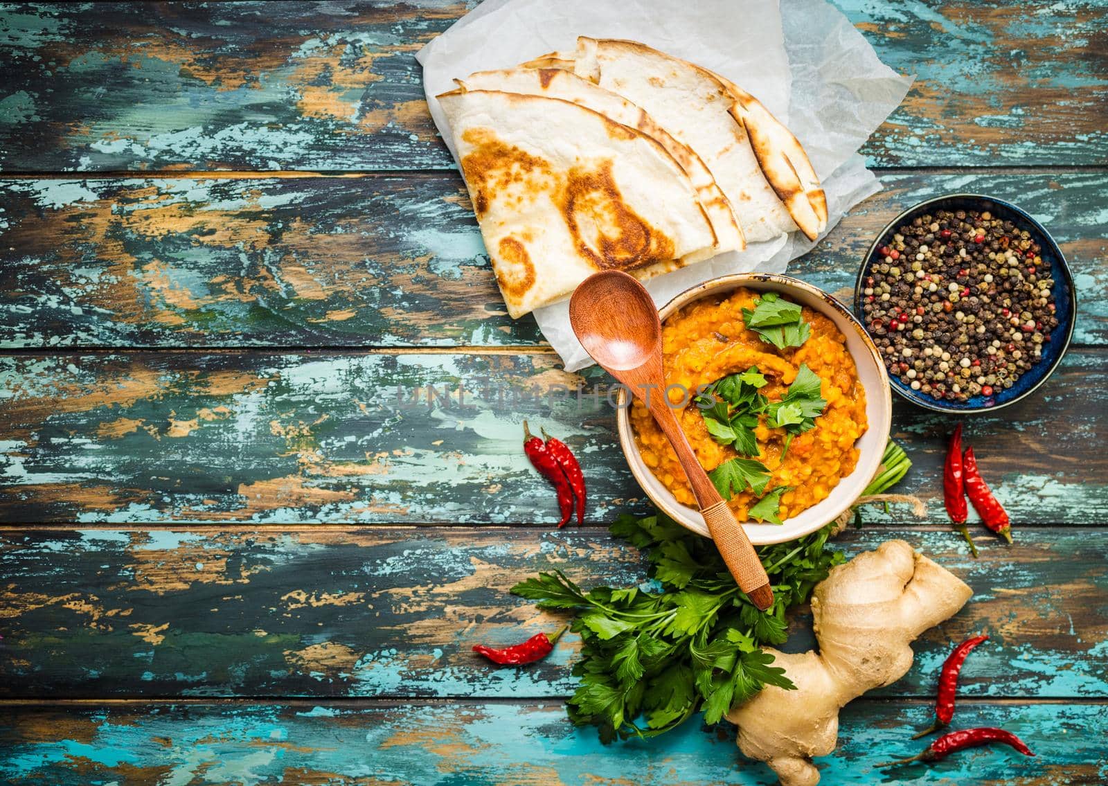 Traditional Indian lentils Dal, naan butter bread. Space for text. Indian Dhal spicy curry in bowl, spices, herbs, rustic wooden background. Top view. Indian food. Authentic Indian dish. Copy space